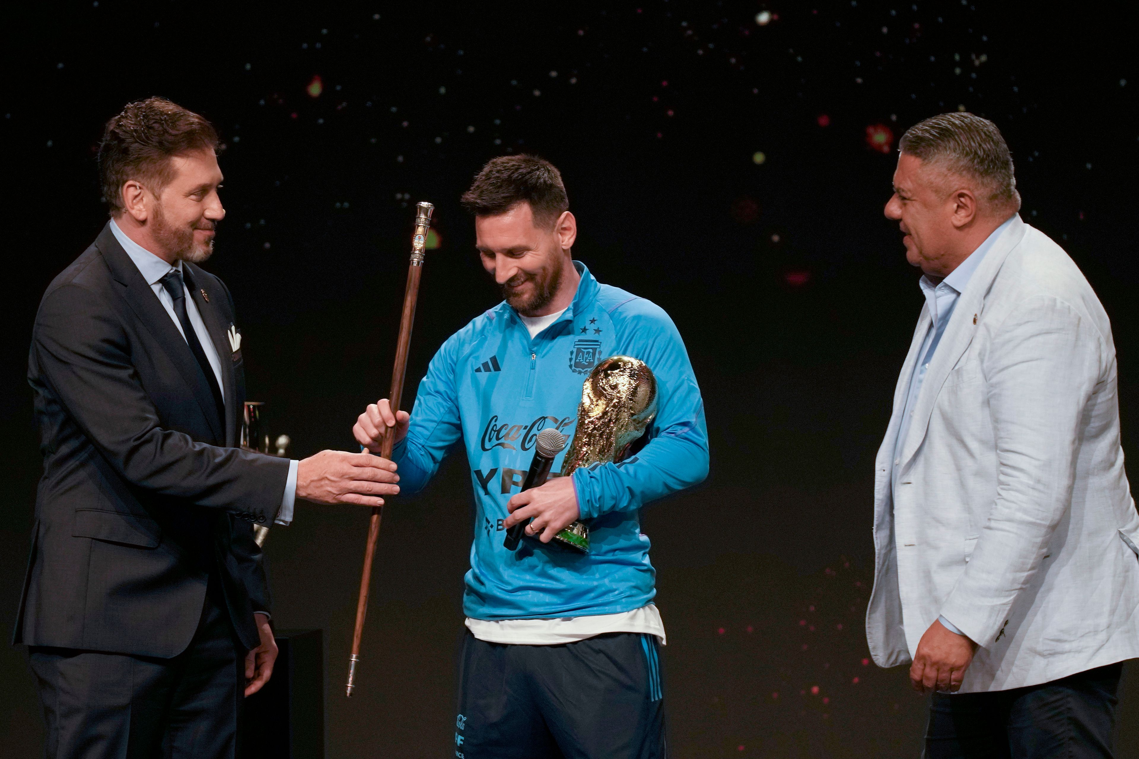 FILE - CONMEBOL President Alejandro Dominguez present to soccer legend Lionel Messi the Leadership and Command of World Soccer baton as Claudio Tapia, president of the Argentina Soccer Association or AFA, looks on during a ceremony at CONMEBOL headquarters in Asuncion, Paraguay, March 27, 2023. (AP Photo/Jorge Saenz, File)