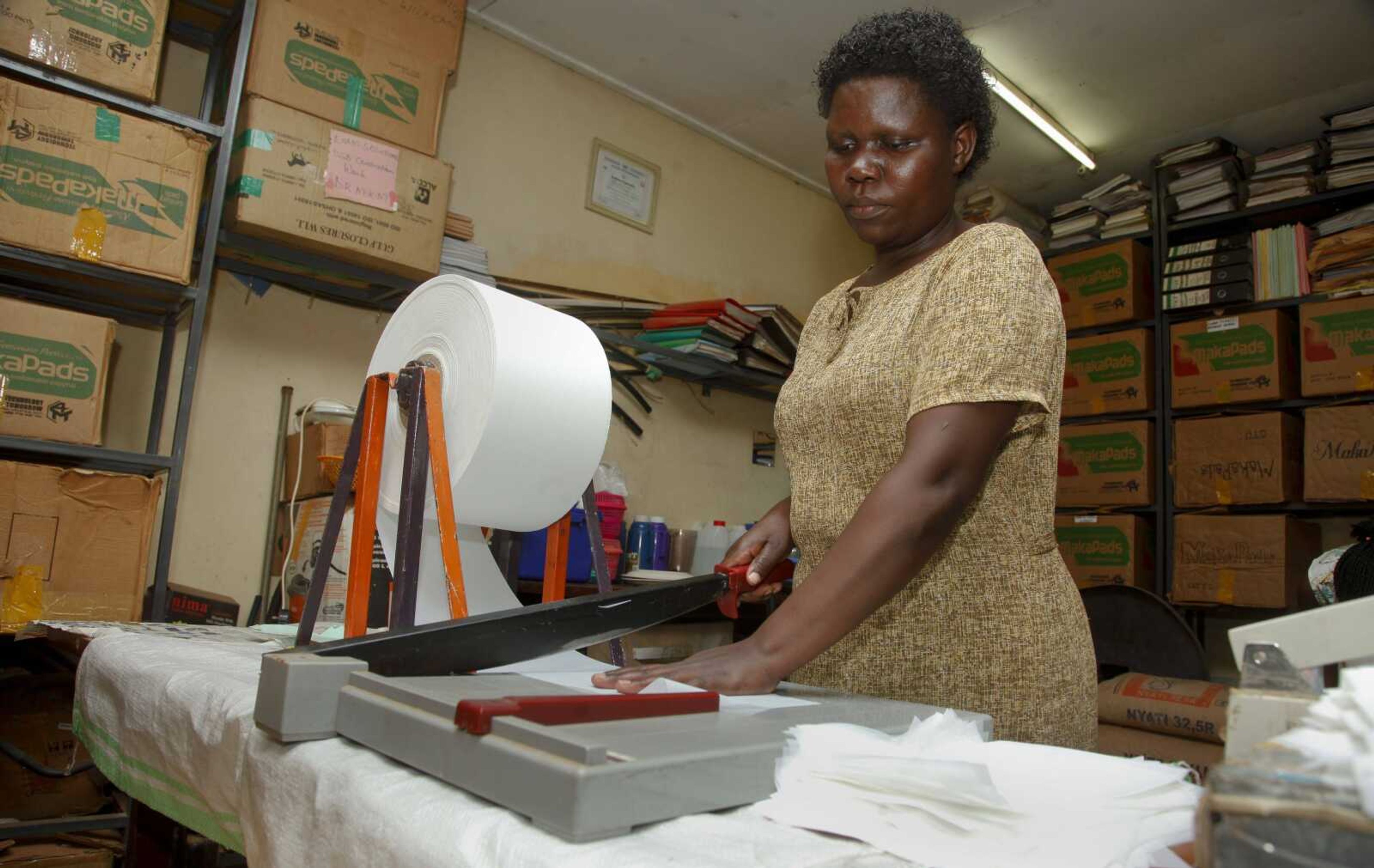 A worker cuts locally made biodegradable sanitary pads known as Makapads that sell for half the price of imported pads at a factory in Kampala, Uganda.