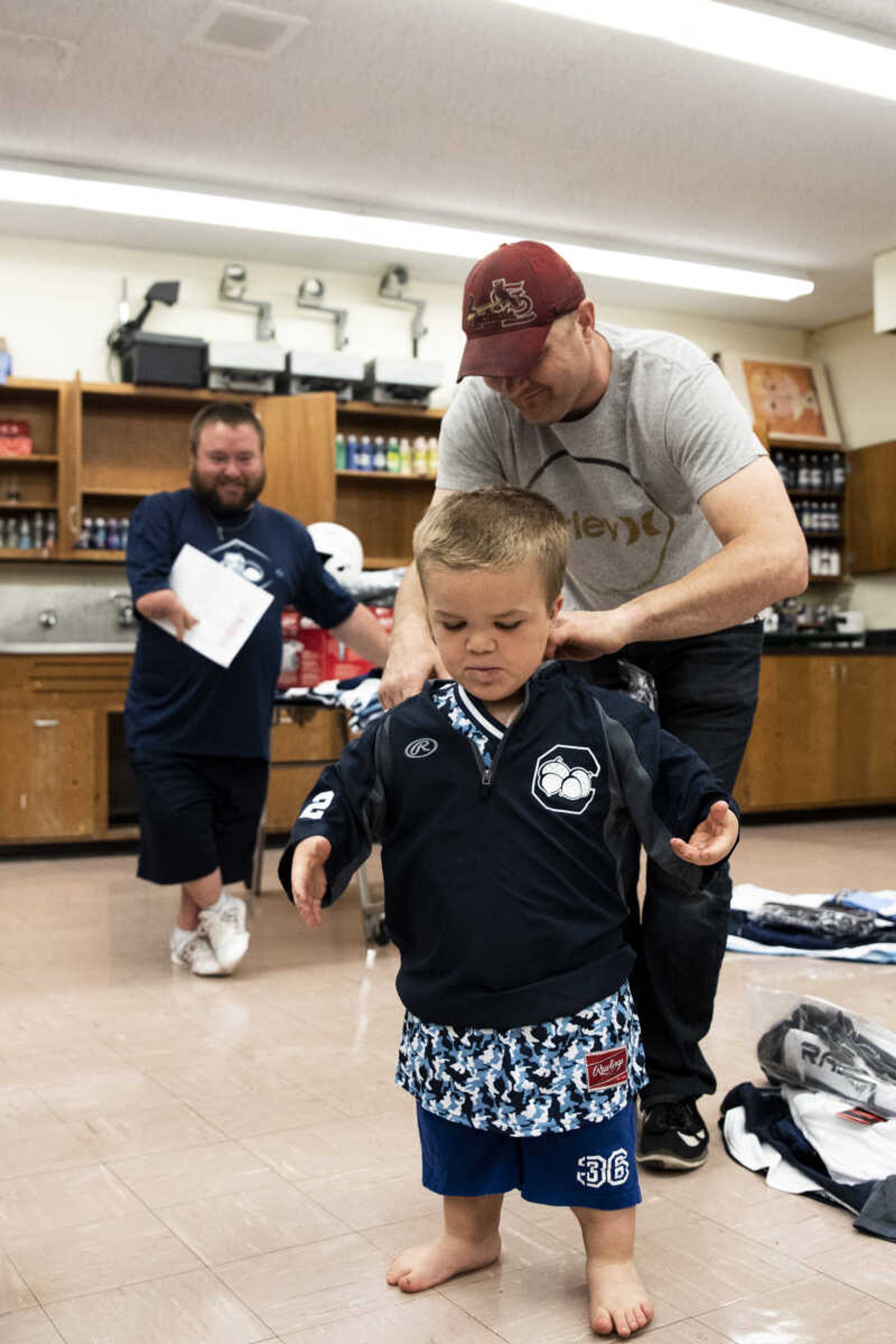 Greg Pursley helps his son Izaac Pursley try on his new Charleston Fighting Squirrel jerseys and gear during jersey pick-up day May 6, 2018 in Charleston.