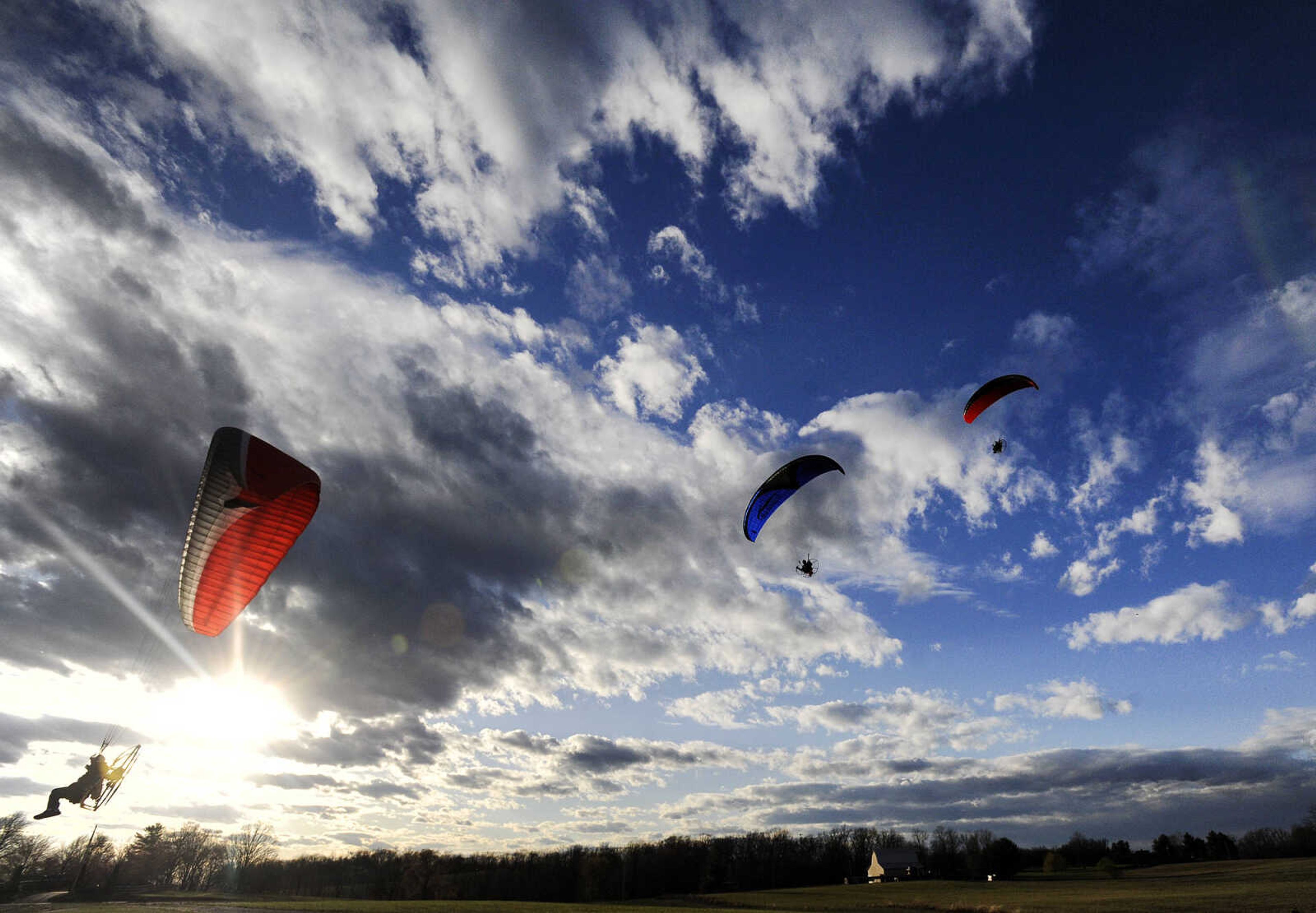 Kevin Rampley, left, Daven Bogenpohl, center, and Curt Froemsdorf fly across the landscape in unison on Thursday, March 2, 2017, at the Fruitland International Airport in Jackson.