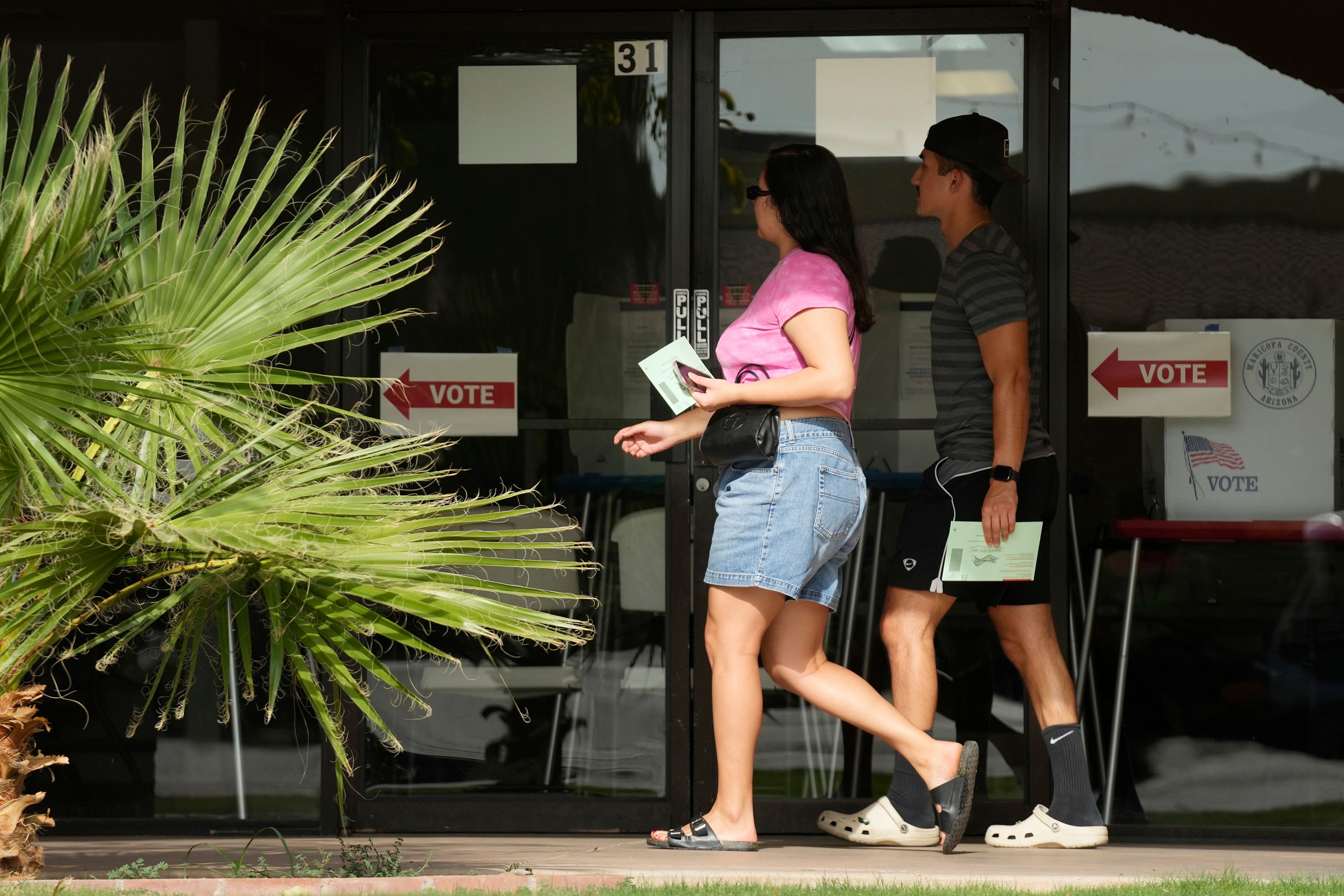 Voters walk to a voting precinct prior to dropping of their ballots Tuesday, July 30, 2024, in Guadalupe, Ariz. (AP Photo/Ross D. Franklin)