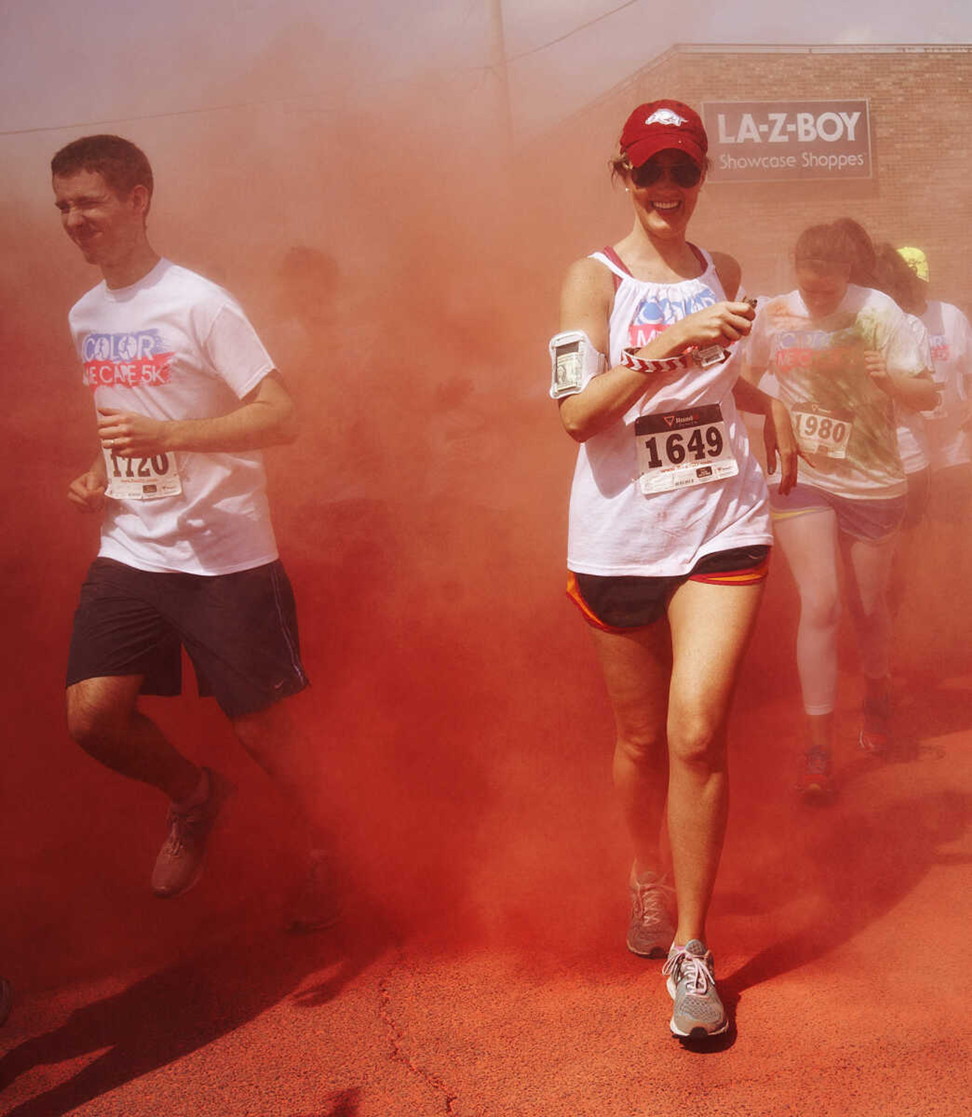 ADAM VOGLER ~ avogler@semissourian.com
Participants in the Color Me Cape 5k are doused with red as they run past the Southeast Missouri State University Cheerleaders near the start Saturday, April 12, in Cape Girardeau.