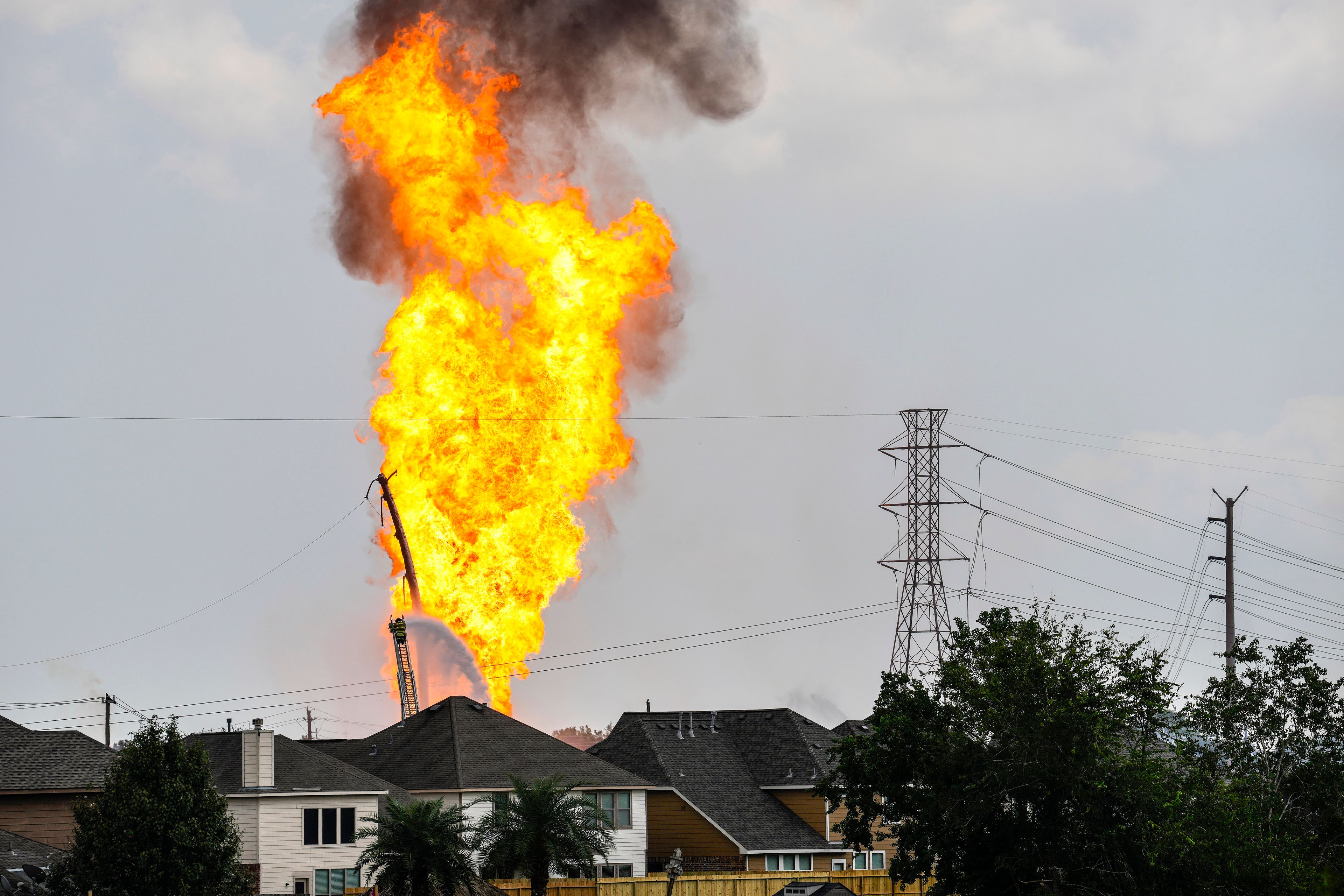 A firefighter directs a line of water around a fire on a pipeline carrying liquified natural gas near Spencer Highway and Summerton on Monday, Sept. 16, 2024, in La Porte, Texas. (Brett Coomer/Houston Chronicle via AP)