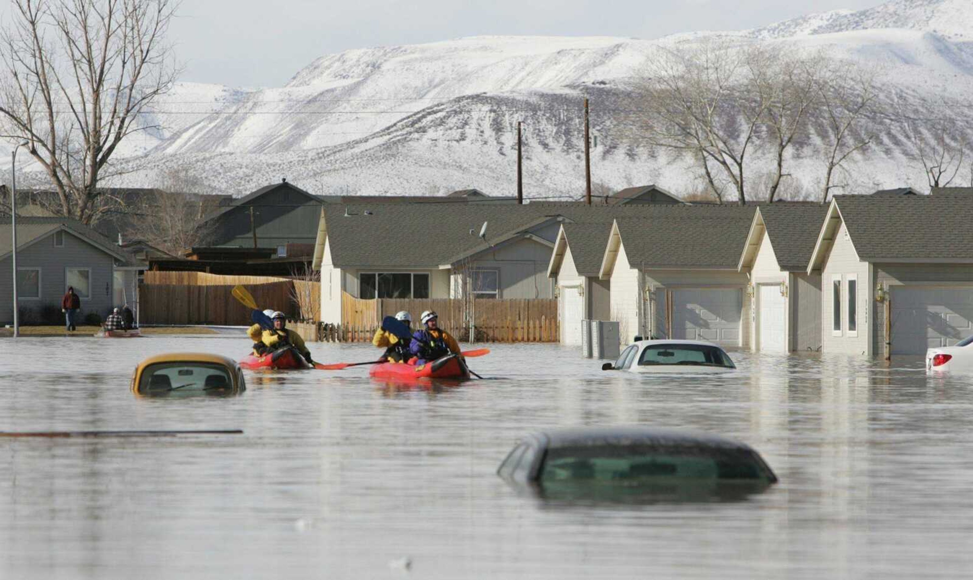 Reno rescue team members searched a neighborhood in Fernley, Nev., on Saturday after a canal levee ruptured from heavy rainfall. (BRAD HORN ~ Nevada Appeal)