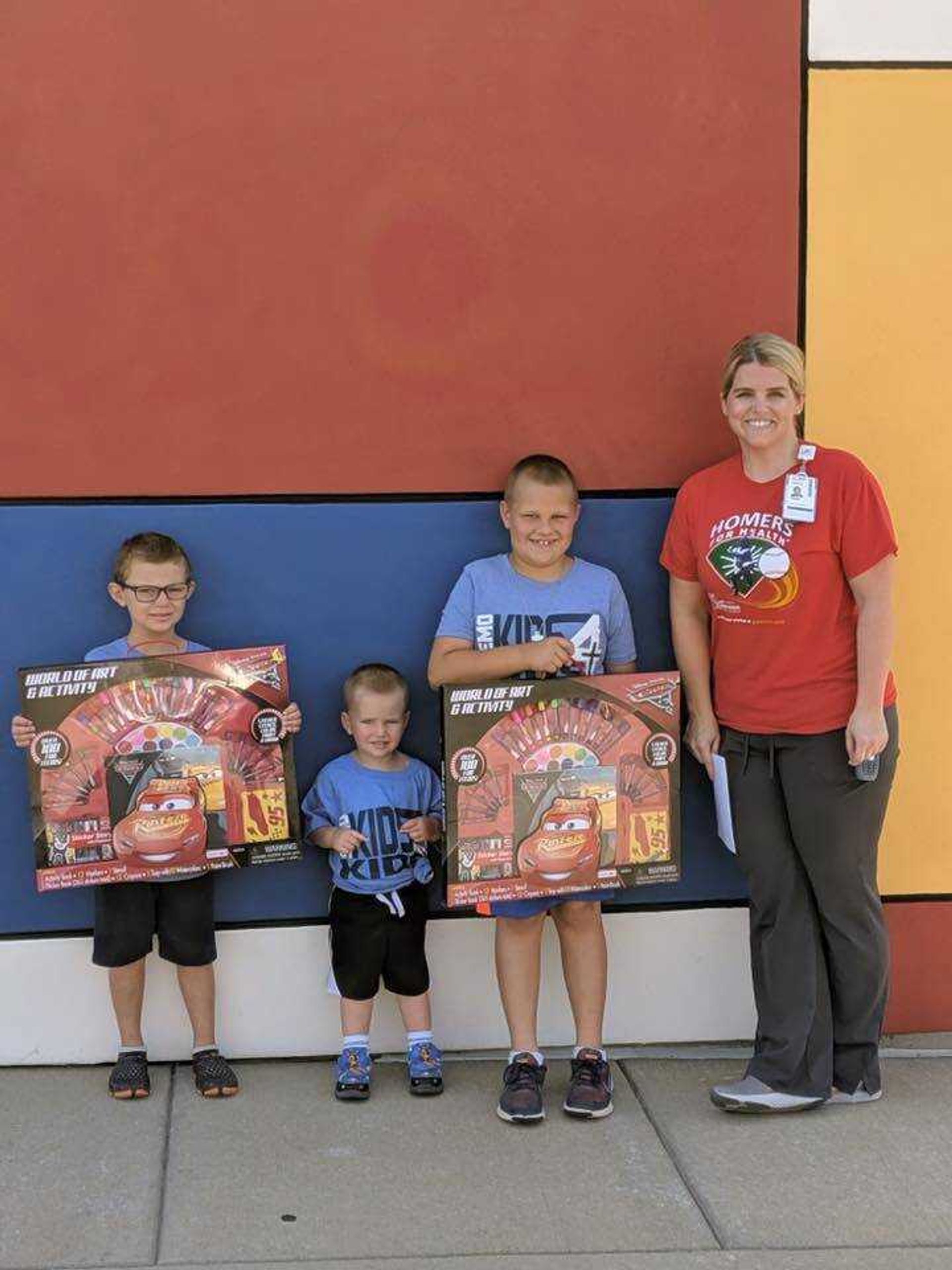 Danny (5), Tommy (2) and Benny (7) post for a picture with a Patient Life Coordinator outside the Cardinal Glennon Children's Foundation. 