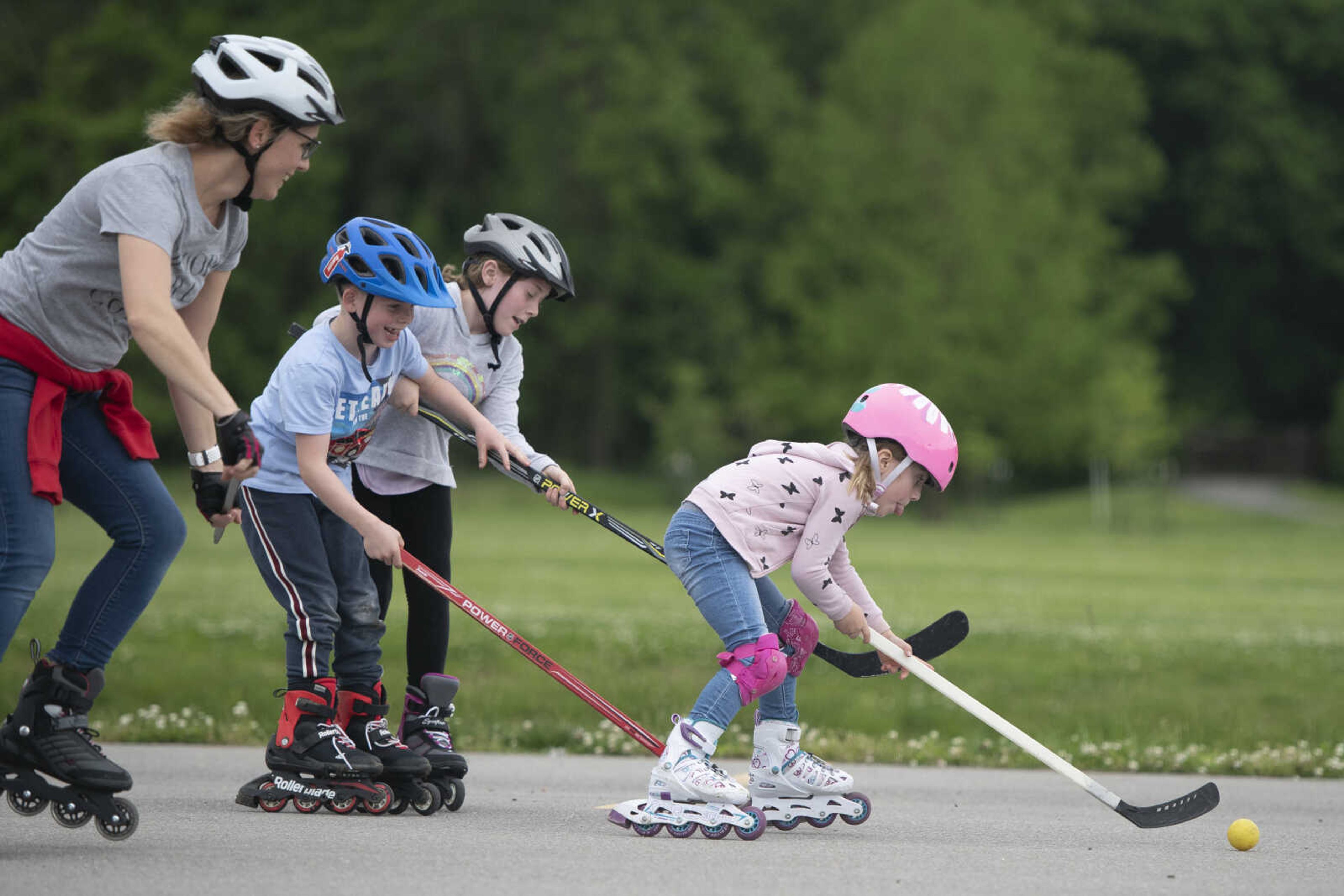 Matilda Booch, 5, goes after a ball near her sister Emma, 9, brother Henri, 7, and mother Maren on Wednesday, May 20, 2020, at a parking lot near Cape Splash Family Aquatic Center in Cape Girardeau.