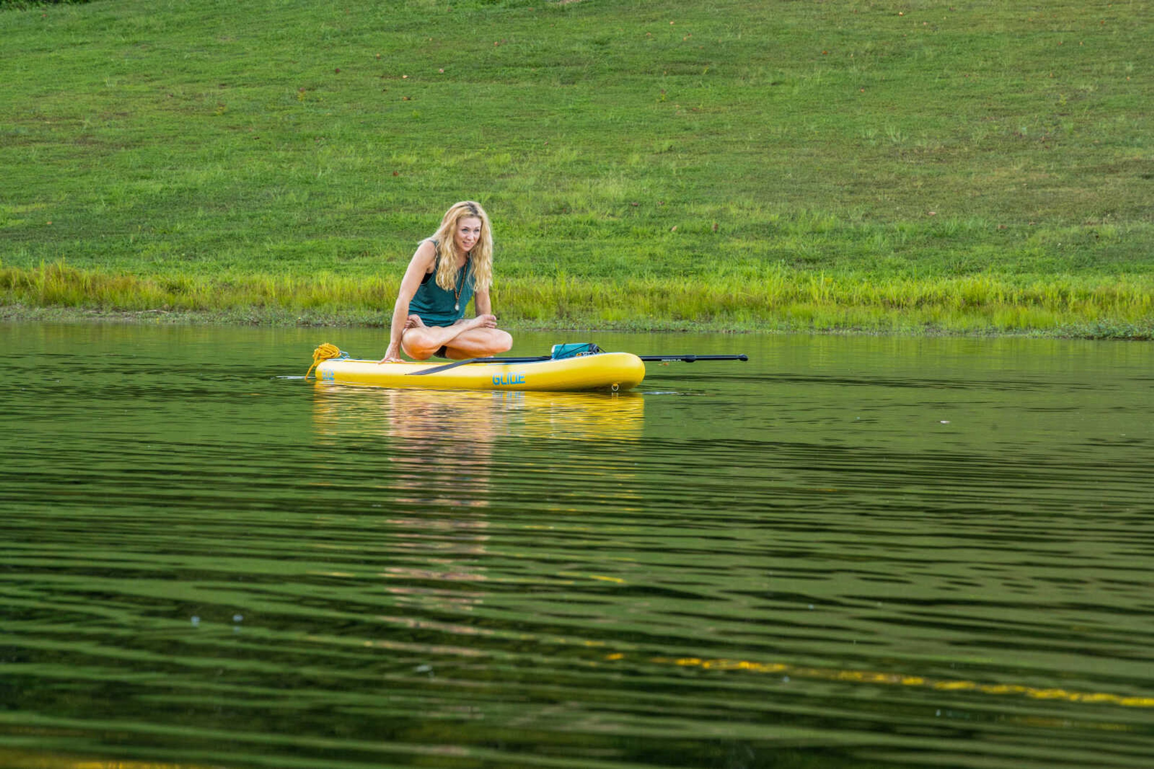 Kelly Downes does a hovering lotus pose while participating in a SUP yoga class at Lake Boutin at Trail of Tears State Park. The water sport combines paddleboarding and yoga.