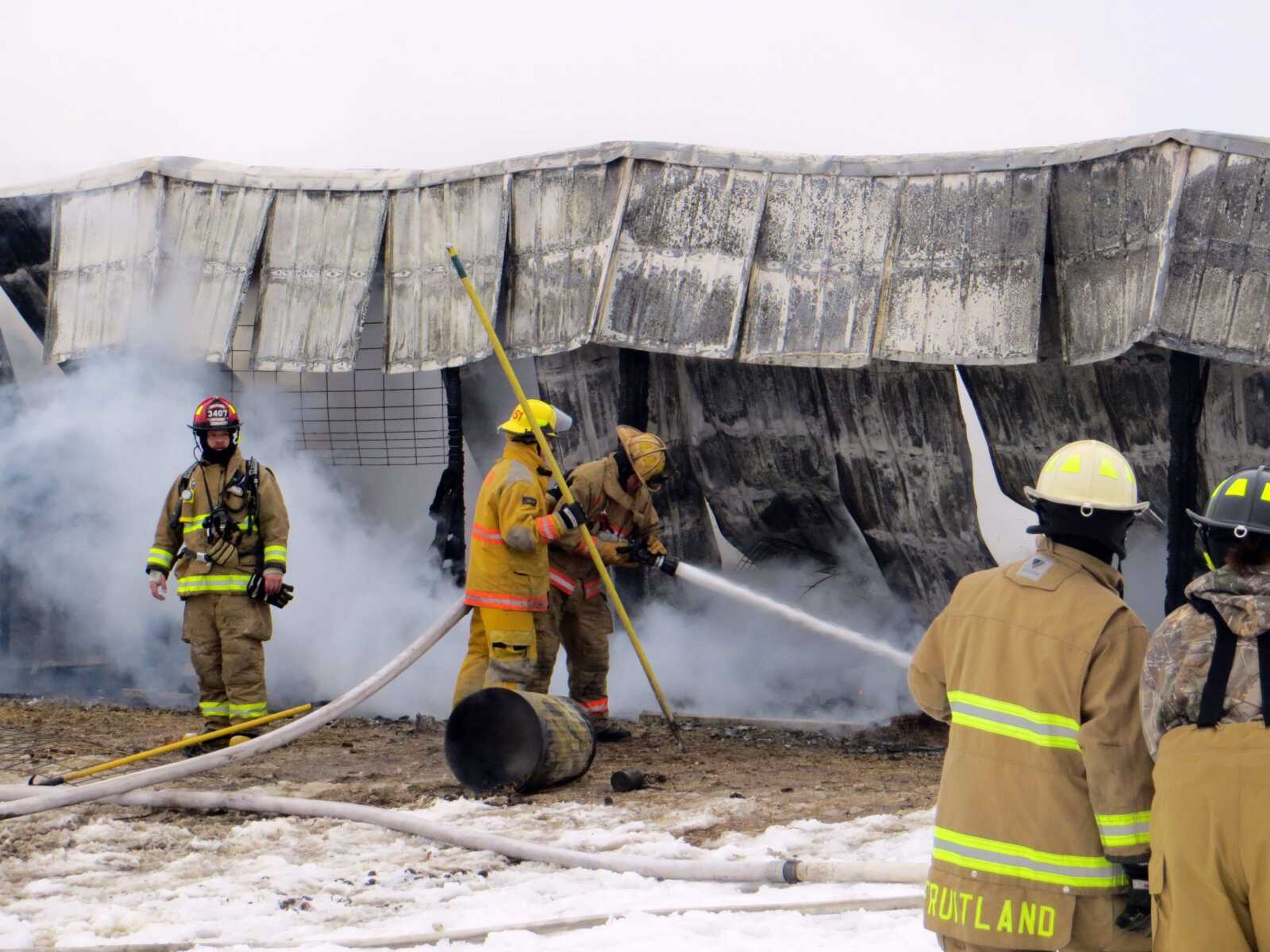 Firefighters try to cool down hot spots after a fire Sunday afternoon destroyed a barn near Fruitland. (Savanna Maue)