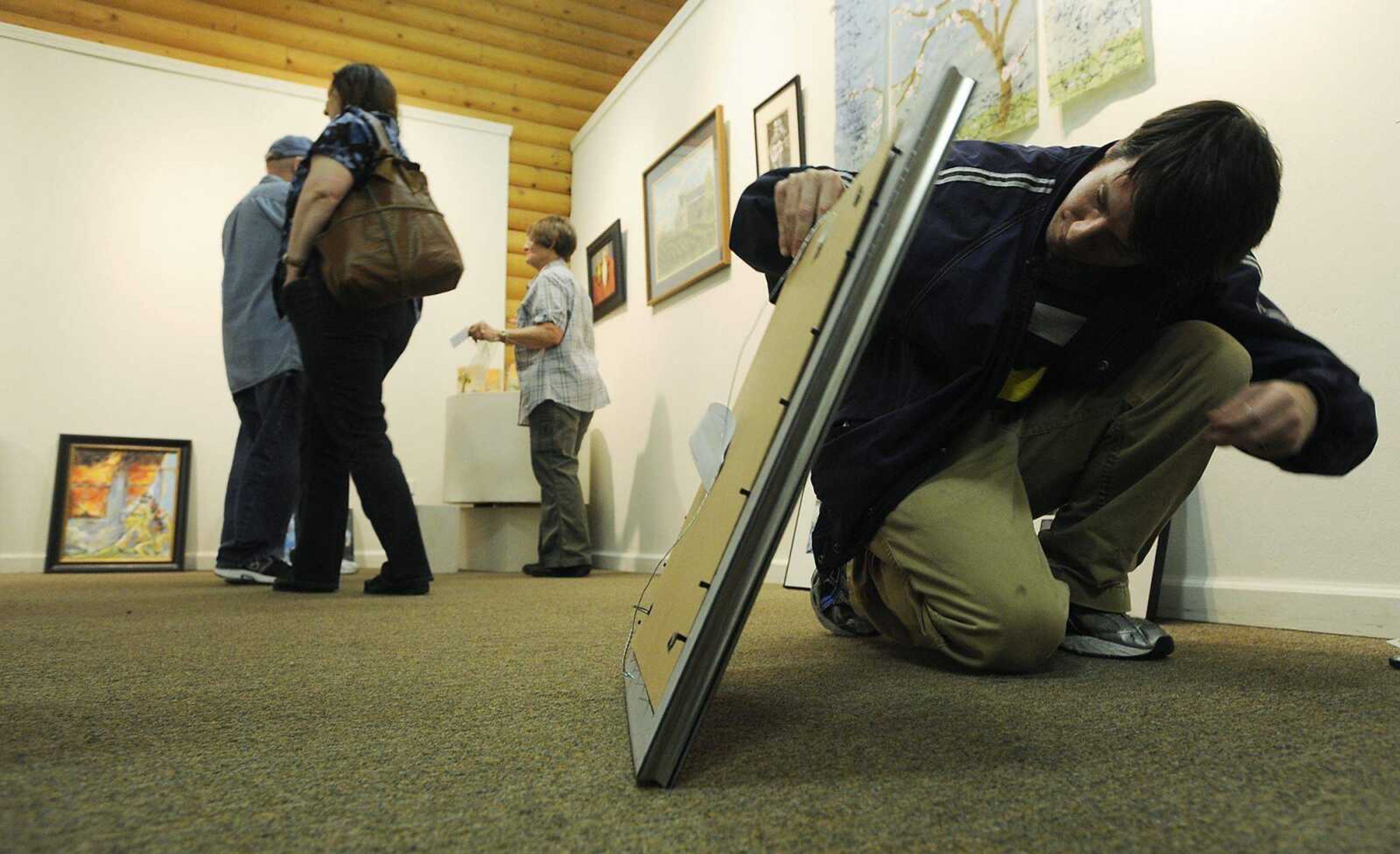 </b>Tim Buerck prepares his photograph, &#8220;Fracture Complement,&#8221; to be hung at the Arts Council of Southeast Missouri at 32 North Main St., in Cape Girardeau on March 30. (ADAM VOGLER ~ avogler@semissourian.com<b>)