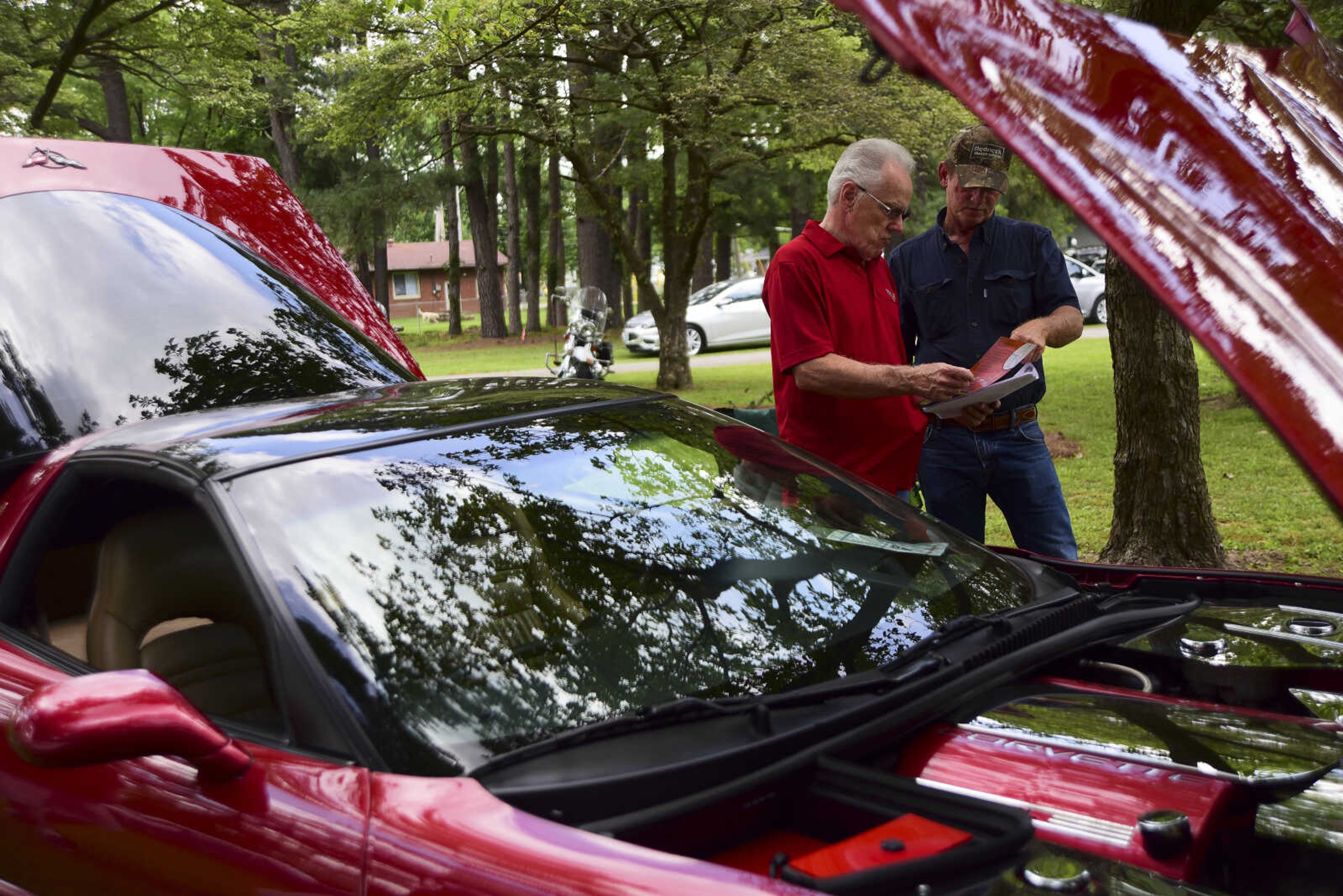 Mike Britton and Kenny Pinkerton look at a 2000 Chevrolet Corvette during the 22nd annual Oran Car Show at George Tilles Jr. Memorial Park Saturday, June 3, 2017 in Oran.