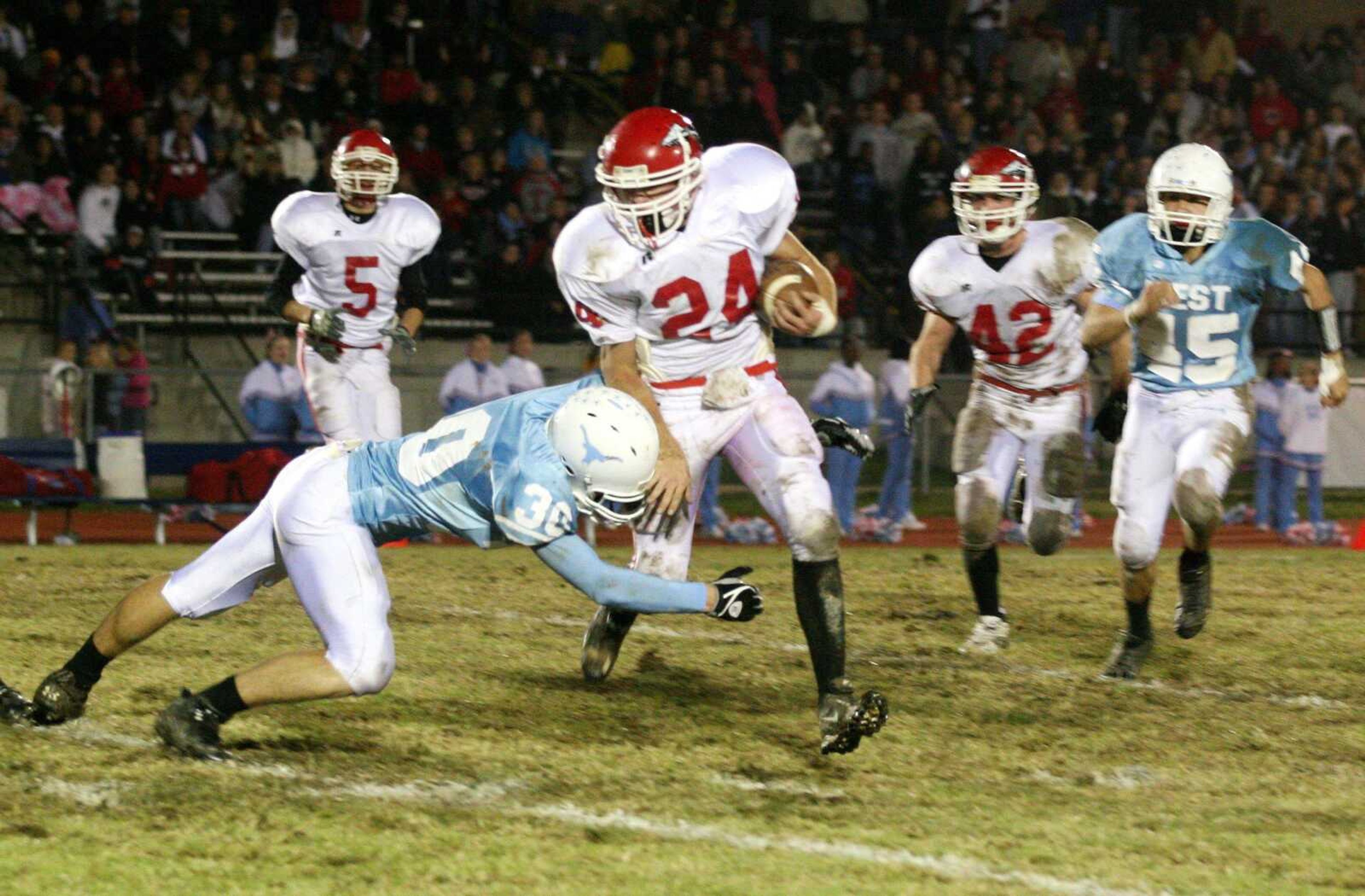 Matt Lang (24) tried to slip through the grasp of Parkway West's Dan Tobik on a punt return during Friday's game. Lang had four interceptions in the game to help the Indians to a 14-6 victory and the Class 5 District 1 title. (PAUL KOPSKY ~ Special to the Southeast Missourian)