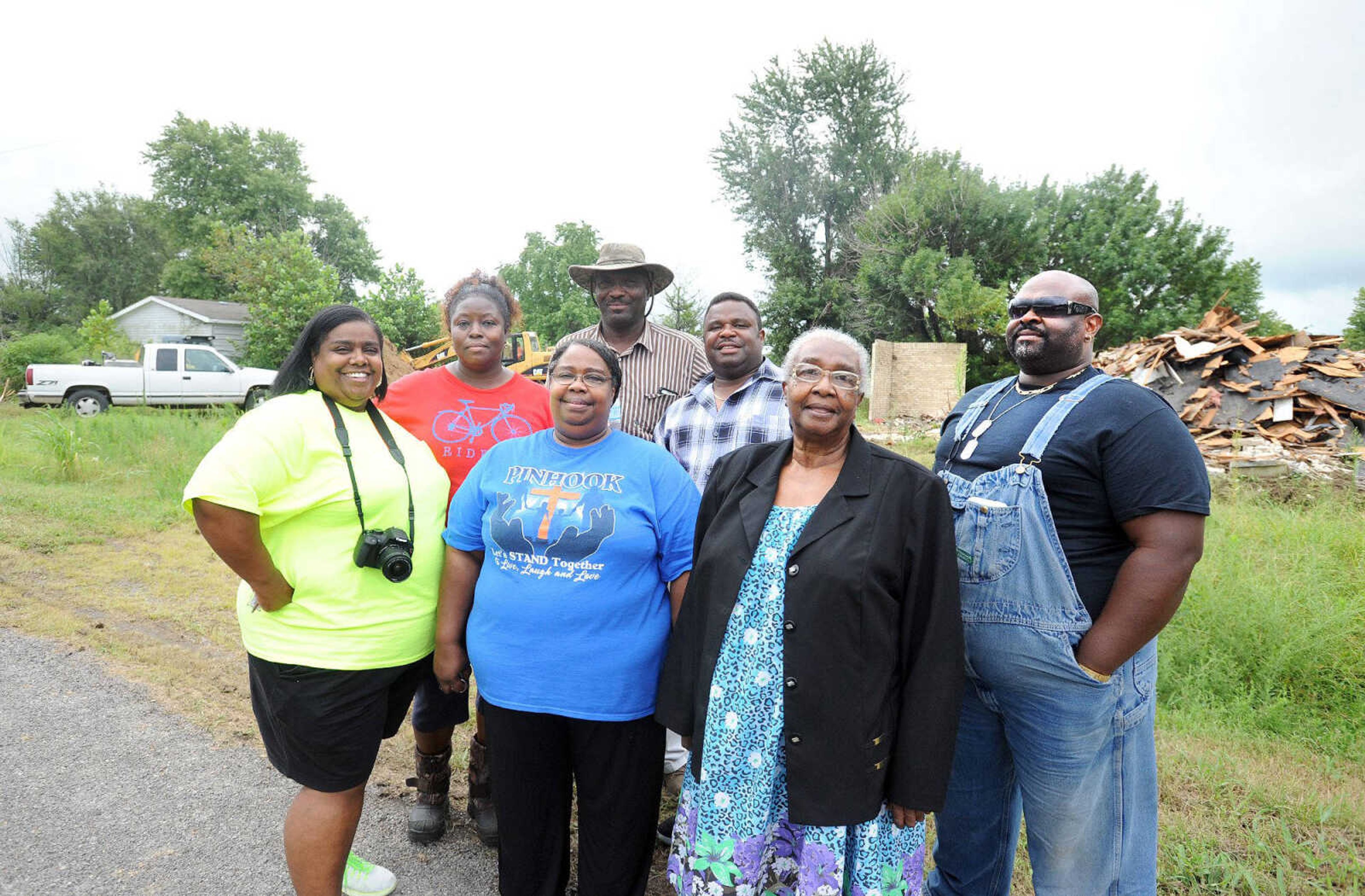 From left, LaToya Robinson-Tate, Gloria Merriweather, Debra Tarver, Leonard Gallion, Reginald Robinson, Aretha Robinson and David Robinson gather together for a group photo as demolition of the remaining homes in Pinhook begins, Thursday, Aug. 6, 2015. Pinhook was ravaged by floodwater in 2011 when the U.S. Army Corp of Engineers breached the Birds Point Levee in Mississippi County to help relieve the swollen Mississippi River. (Laura Simon)