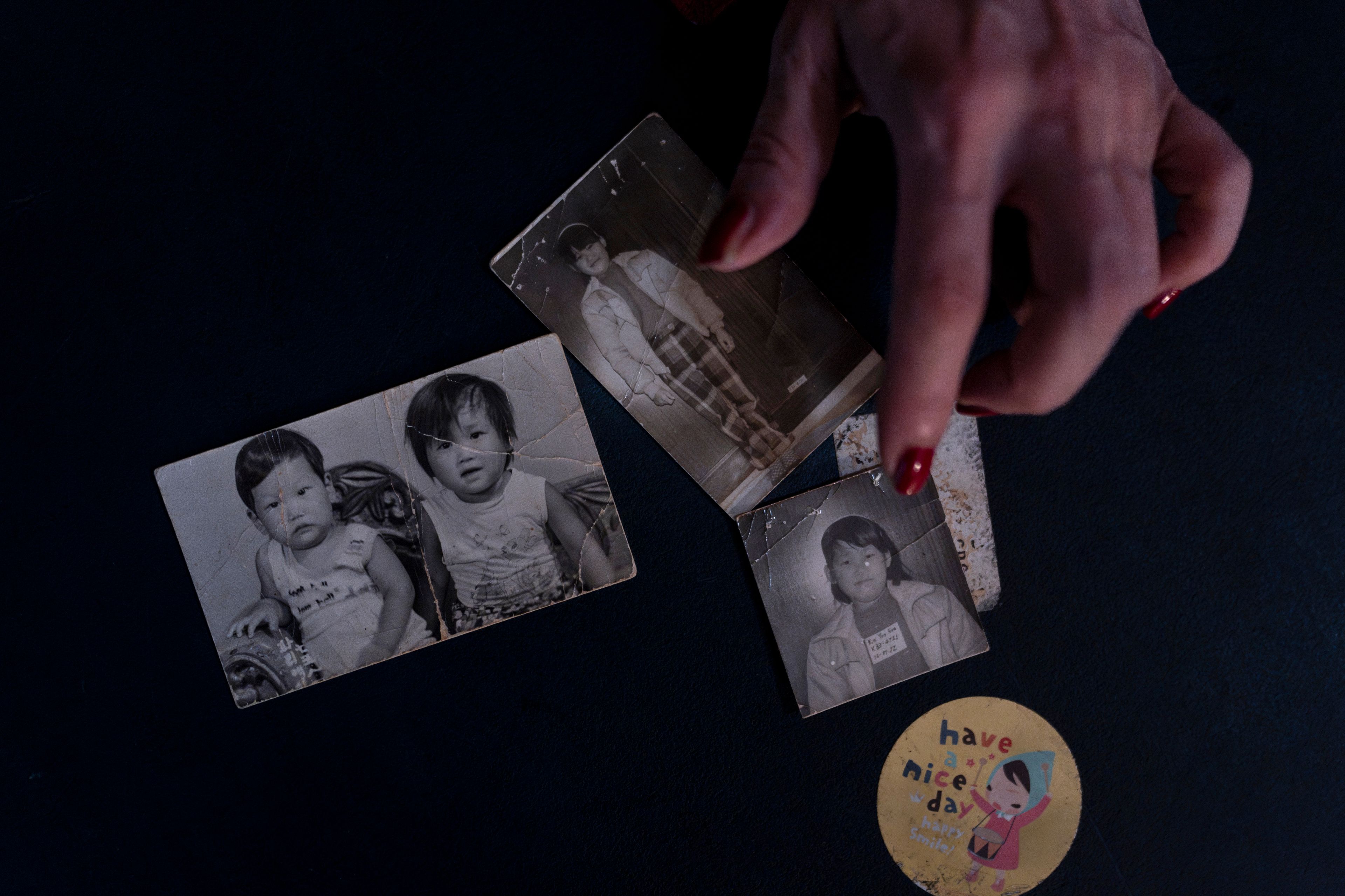 Yooree Kim, who was sent to a couple in France by the Holt adoption agency when she was 11, displays some old photos of her and her brother in her apartment in Seoul, Saturday, May 18, 2024. (AP Photo/Jae C. Hong)