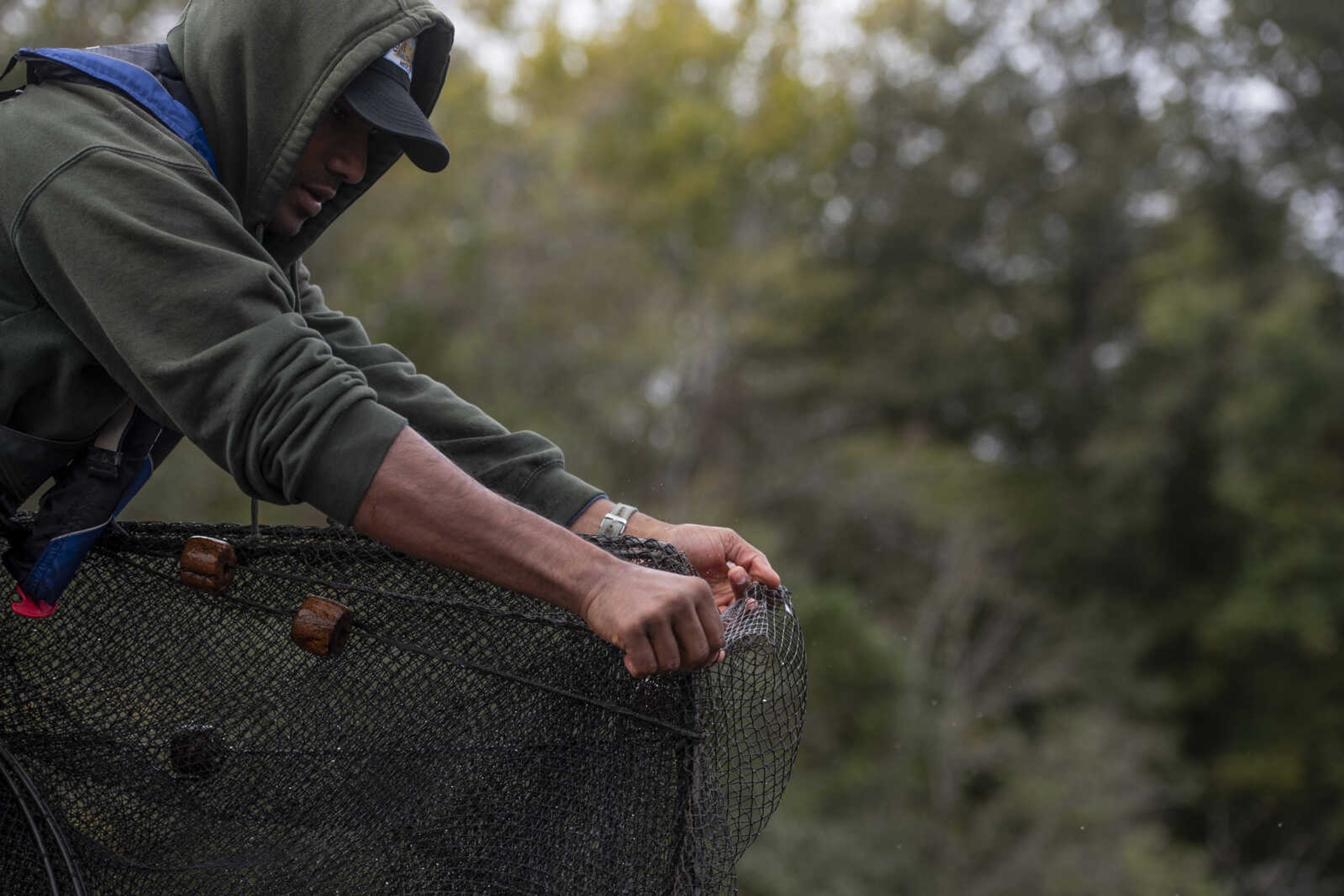 Sindupa De Silva, fisheries management assistant and naturalist, wraps up a net used for sampling fish out of Lake Girardeau Tuesday, Oct. 16,2018, in Whitewater.