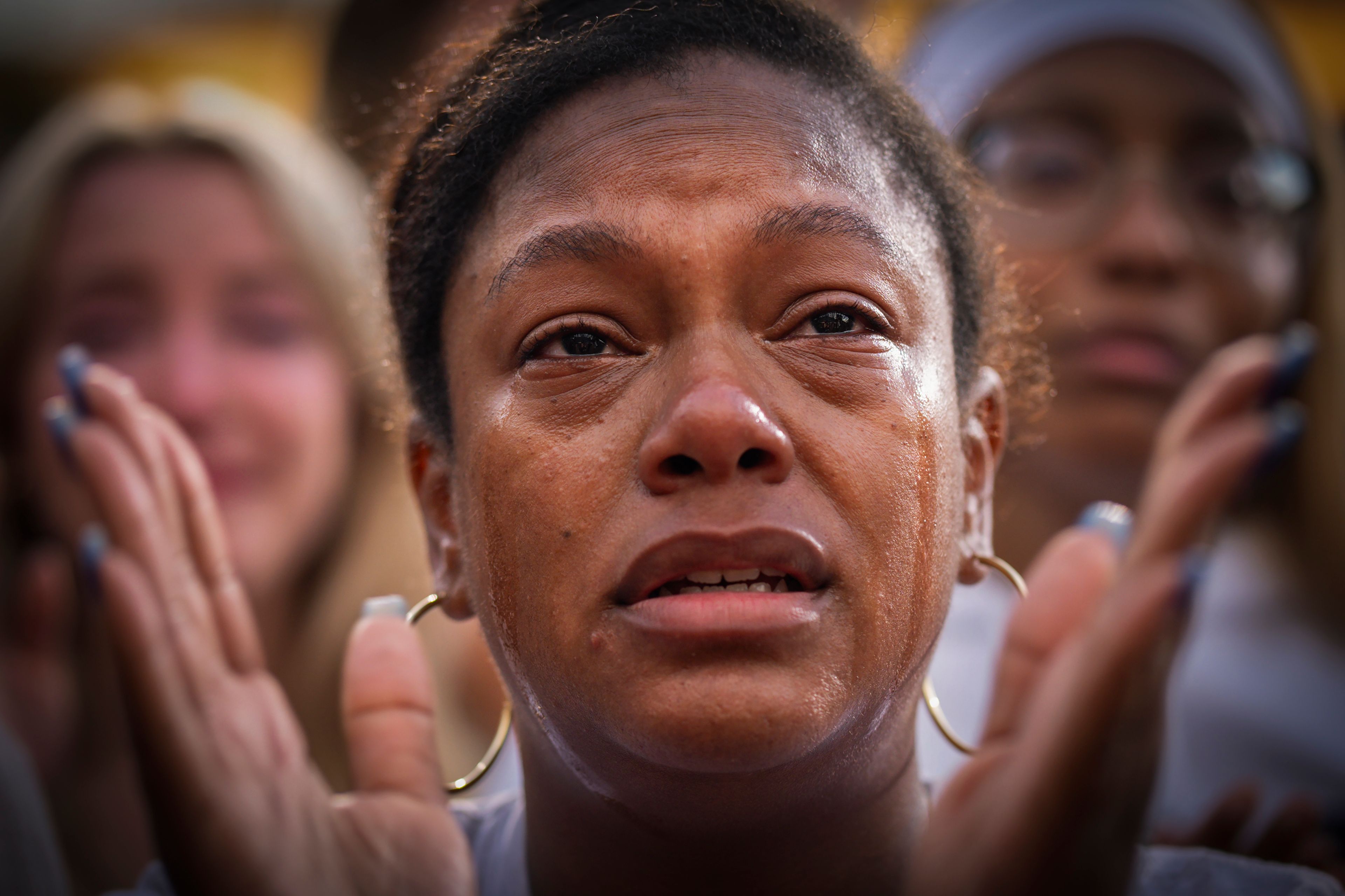 With tears streaming down her face, a supporter of Democratic presidential nominee Vice President Kamala Harris applauds as Harris delivers a concession speech on Nov. 6, 2024, after losing the 2024 presidential election, on the campus of Howard University in Washington. (AP Photo/Jacquelyn Martin)