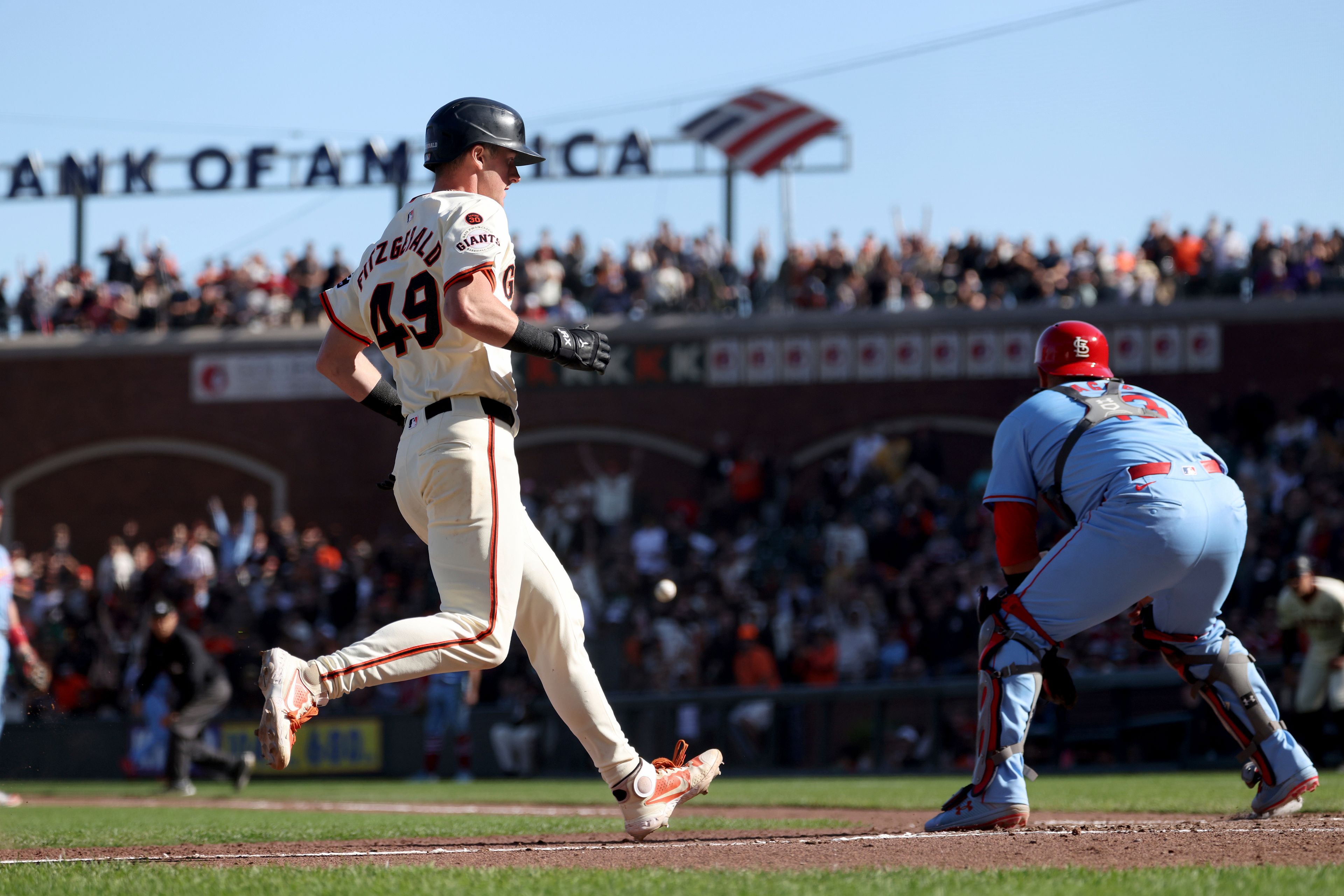 San Francisco Giants' Tyler Fitzgerald (49) scores in front of St. Louis Cardinals catcher Pedro Pagés, right, on a throwing error by pitcher Matthew Liberatore during the eighth inning of a baseball game in San Francisco, Saturday, Sept. 28, 2024. (AP Photo/Jed Jacobsohn)