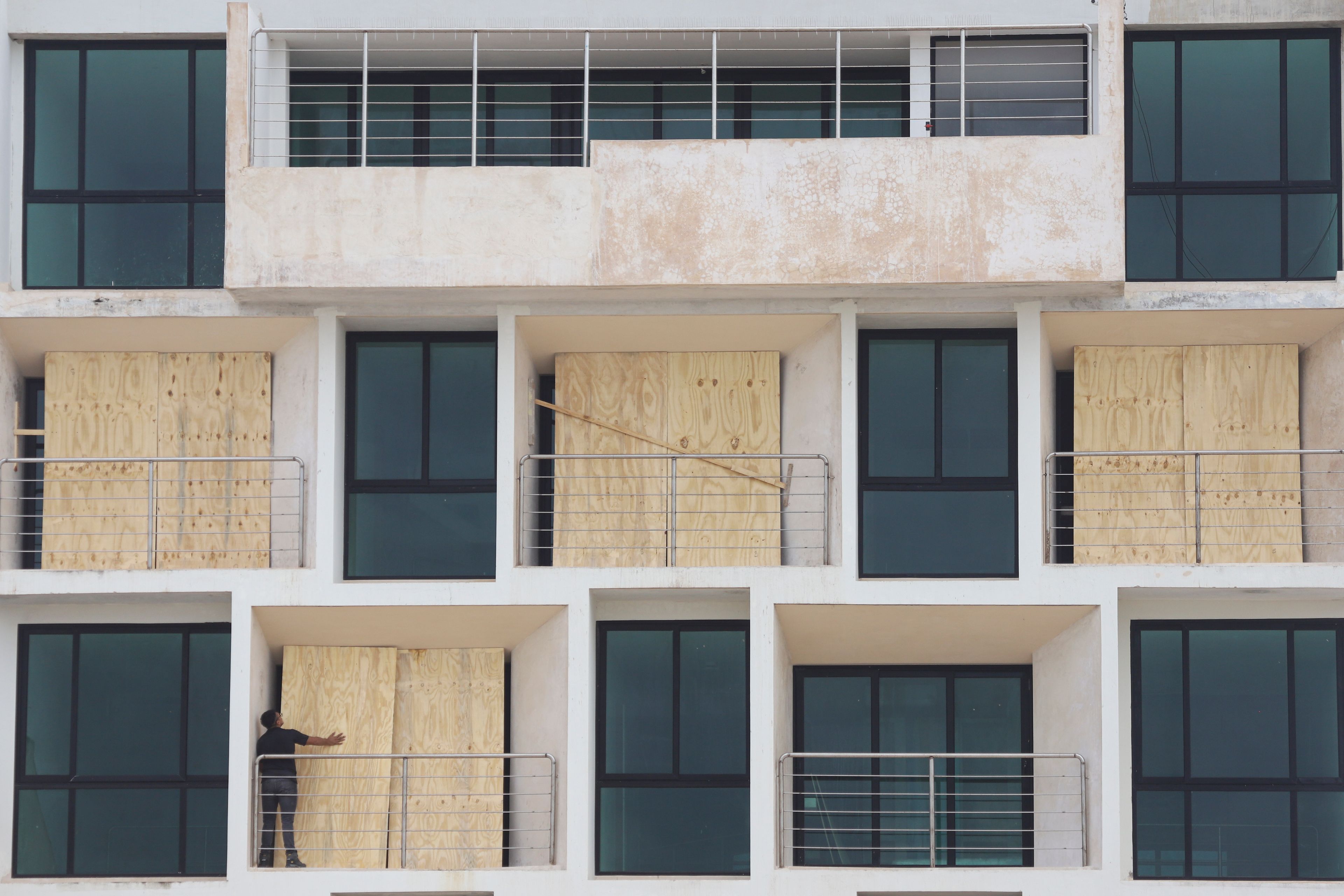 A man boards up an apartment building to protect it from Hurricane Milton, in Progreso, Yucatan state, Mexico, Monday, Oct. 7, 2024. (AP Photo/Martin Zetina)