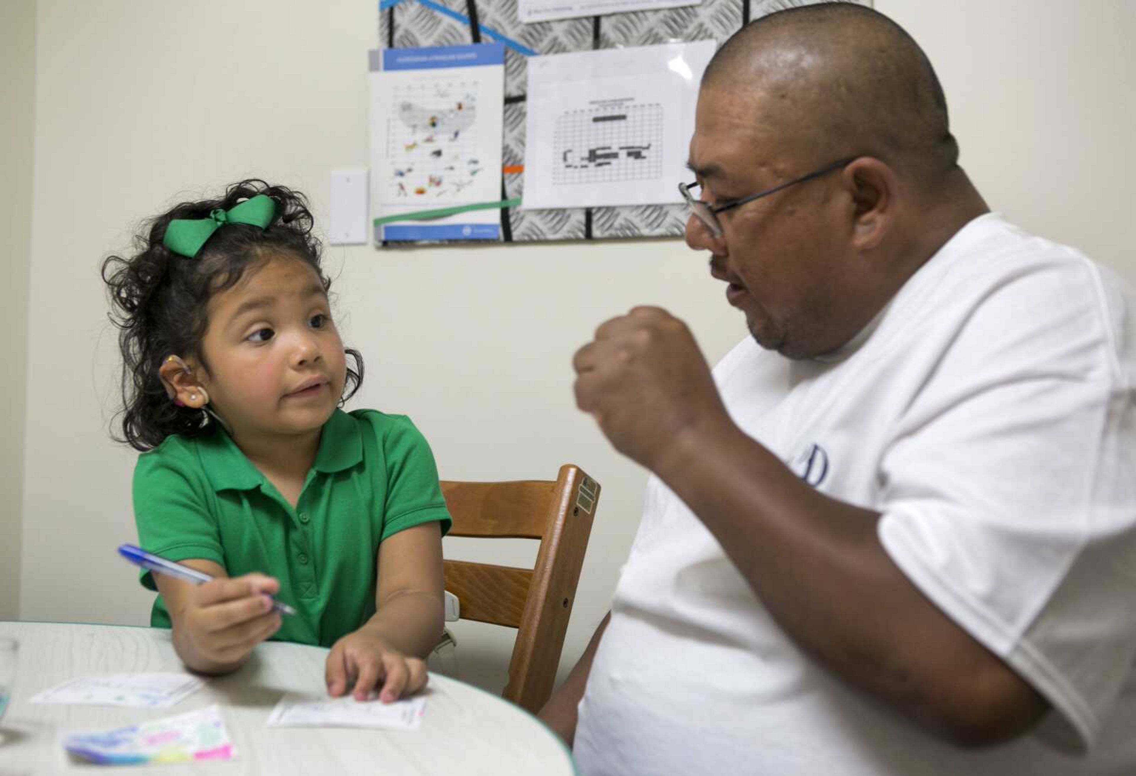 Angelica Lopez, 3, writes her name with the help of her father, Santos Lopez, during a therapy session at the University of Southern California in Los Angeles. Angelica was born deaf and received an auditory brainstem implant to allow her to hear some sounds as part of a research study into the devices' use in young children. (Damian Dovarganes ~ Associated Press)