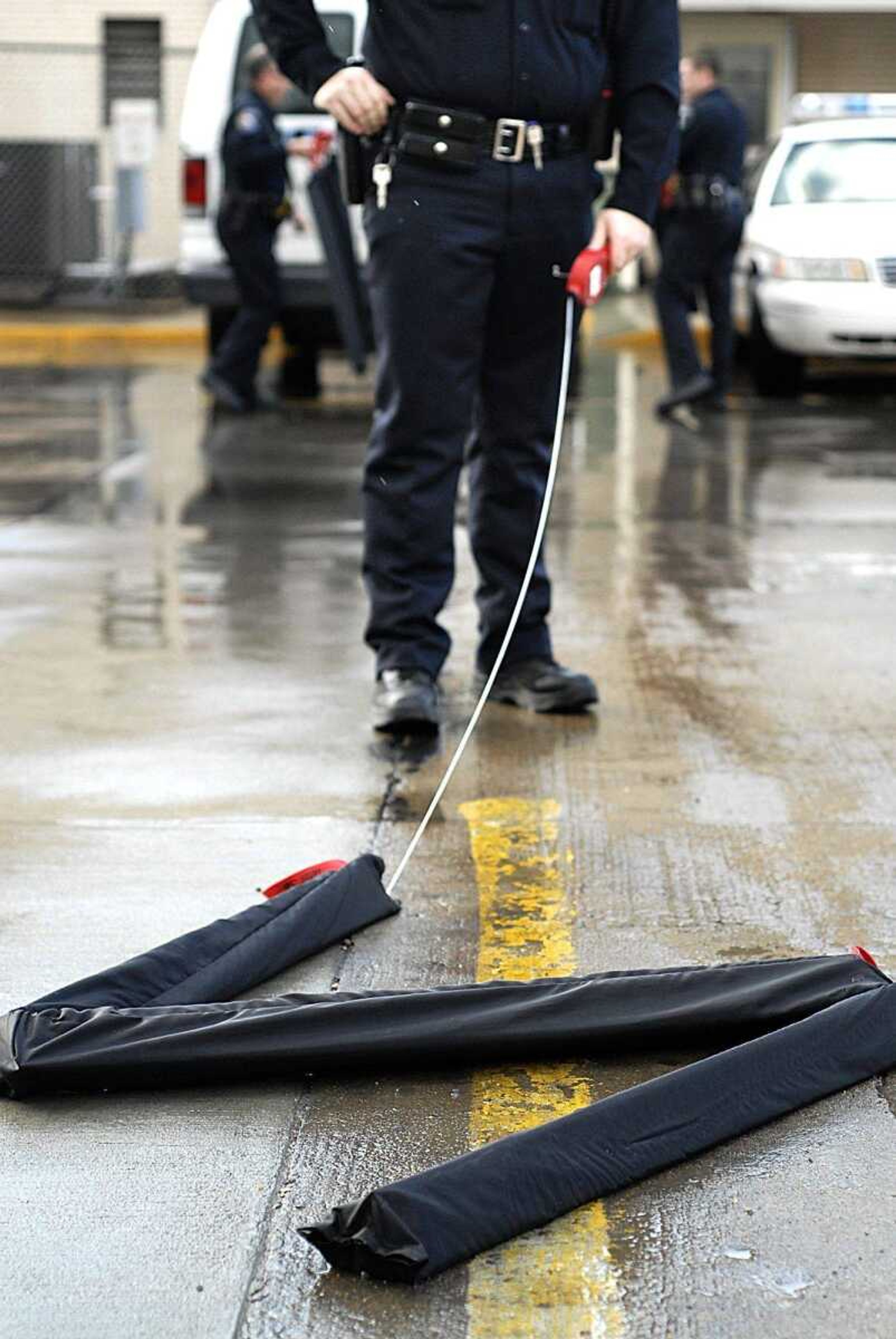 Patrolman Jim Zeidler of the Cape Girardeau Police Department laid down a set of Stop Sticks and moved to the other side of the driving surface during a training session for the new device Tuesday at the police station. The Stop Sticks contain spikes that are designed to puncture the tires of a fleeing vehicle. (Aaron Eisenhauer)