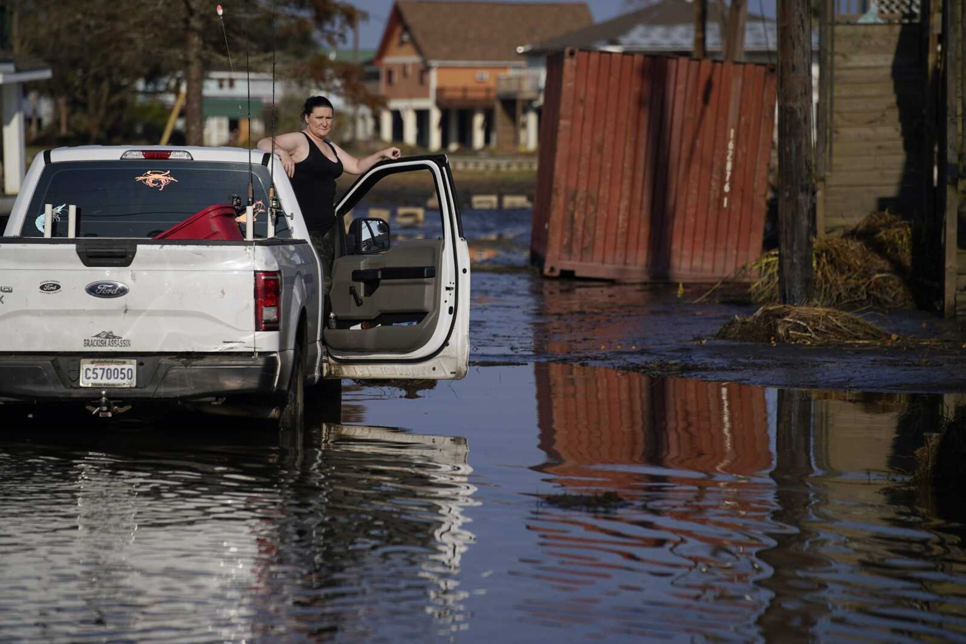 Shannon Lation checks on her home destroyed by Hurricane Ida, Sunday, Sept. 5, 2021, in Lafitte, La. (AP Photo/John Locher)