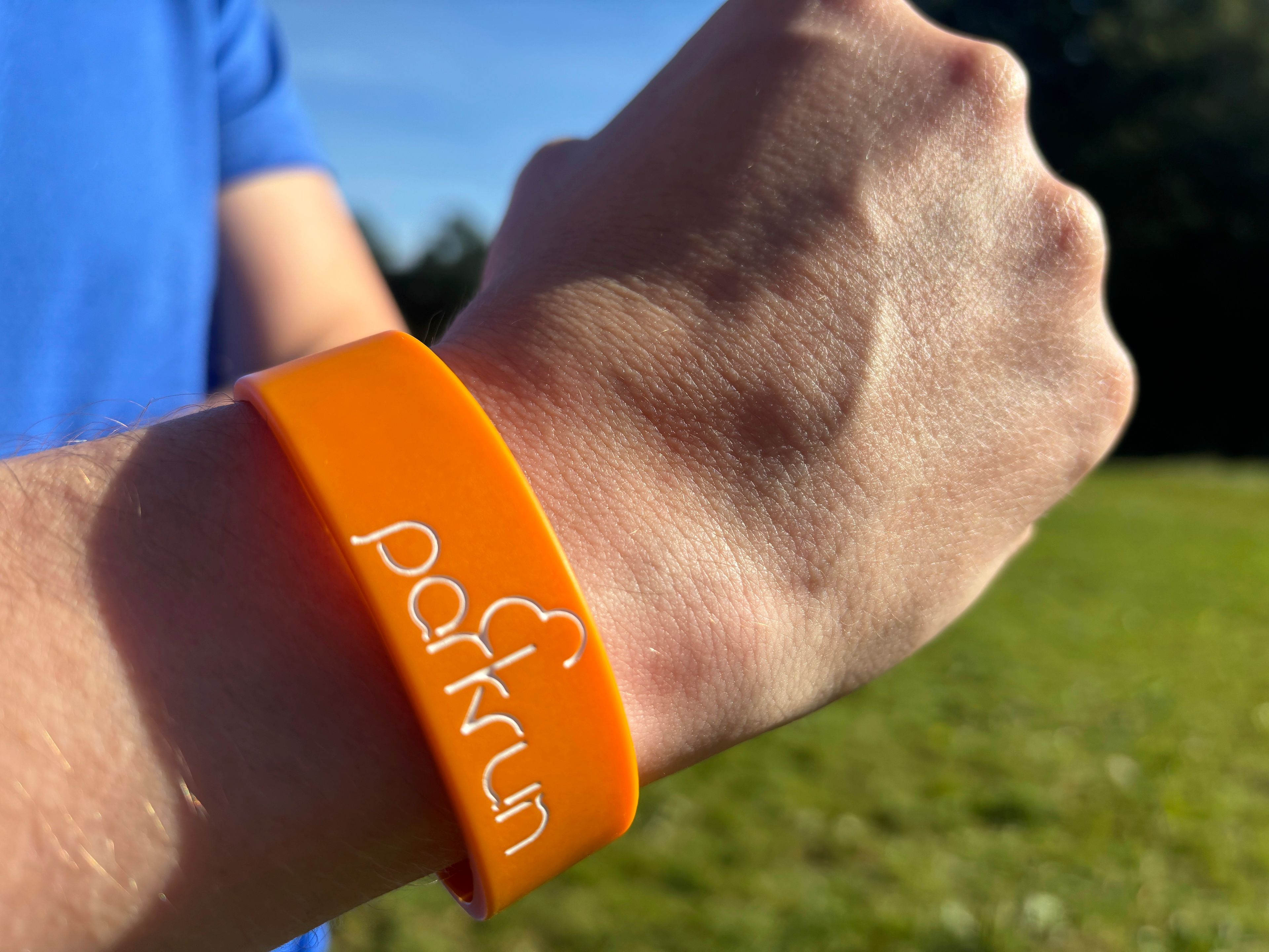 A runner shows off a parkrun wrist band after completing the 5 kilometer (3.1 mile) route in Hampstead Heath in north London on Saturday Sept. 14, 2024. (AP Photo/Lucy Nicholson)