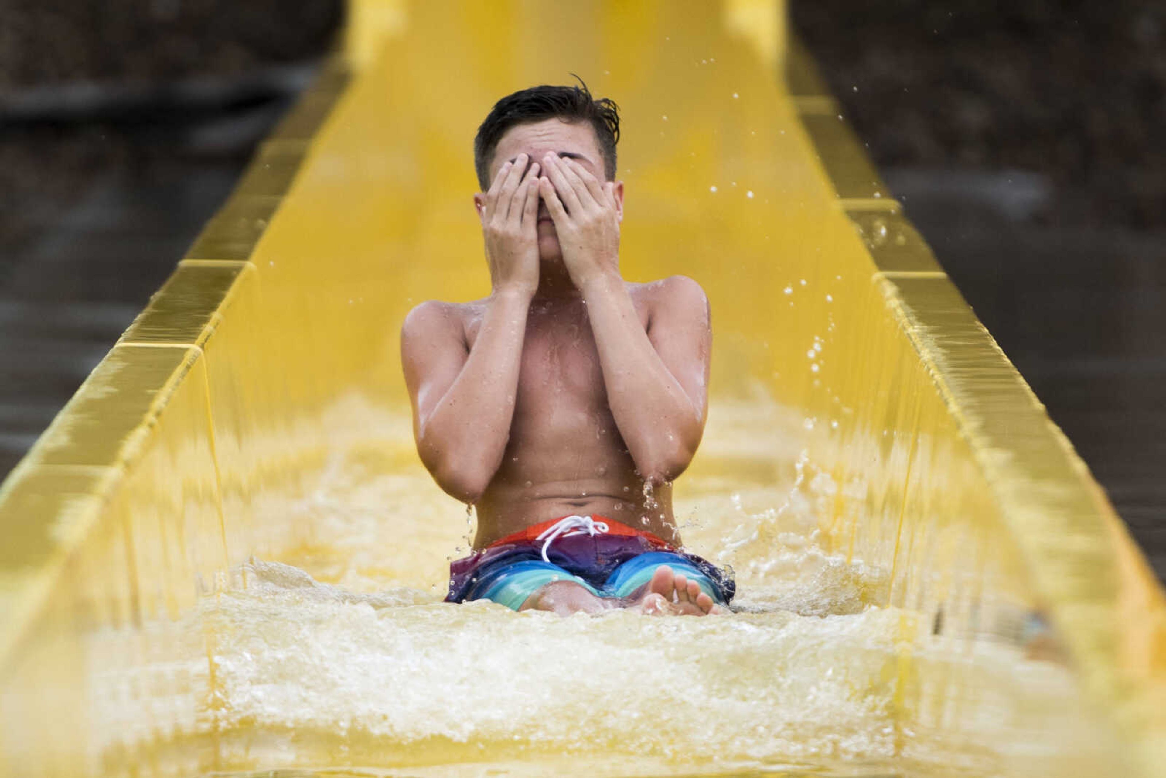 A child wipes water from his eyes after reaching the bottom of a speed slide Sunday, Aug. 11, 2019, at Cape Splash in Cape Girardeau.