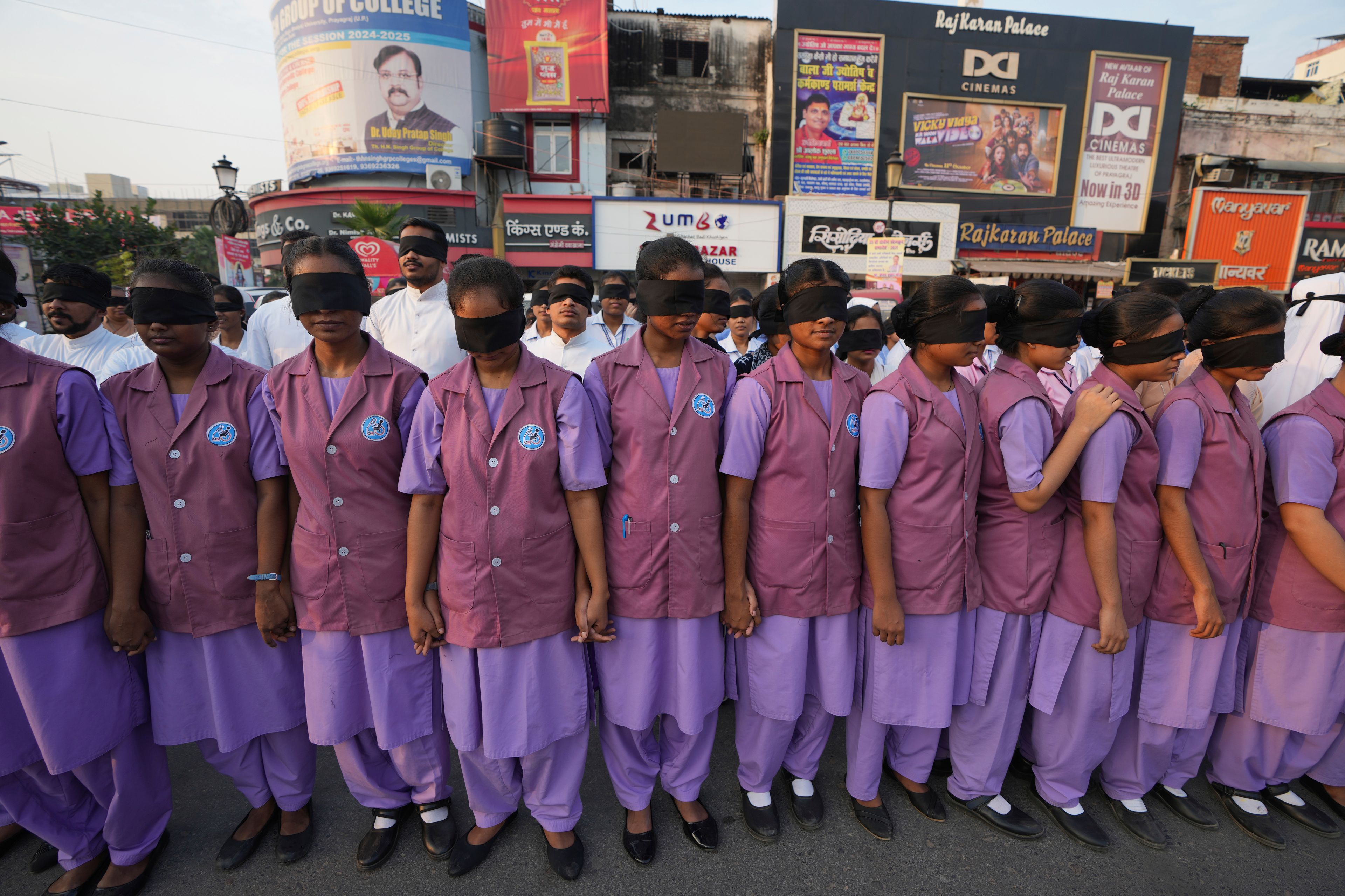 Indian nursing students wearing black ribbon over their eyes, walk with blind children during a rally on World Sight Day in Prayagraj, Uttar Pradesh, India, Thursday, Oct. 10, 2024. (AP Photo/Rajesh Kumar Singh)