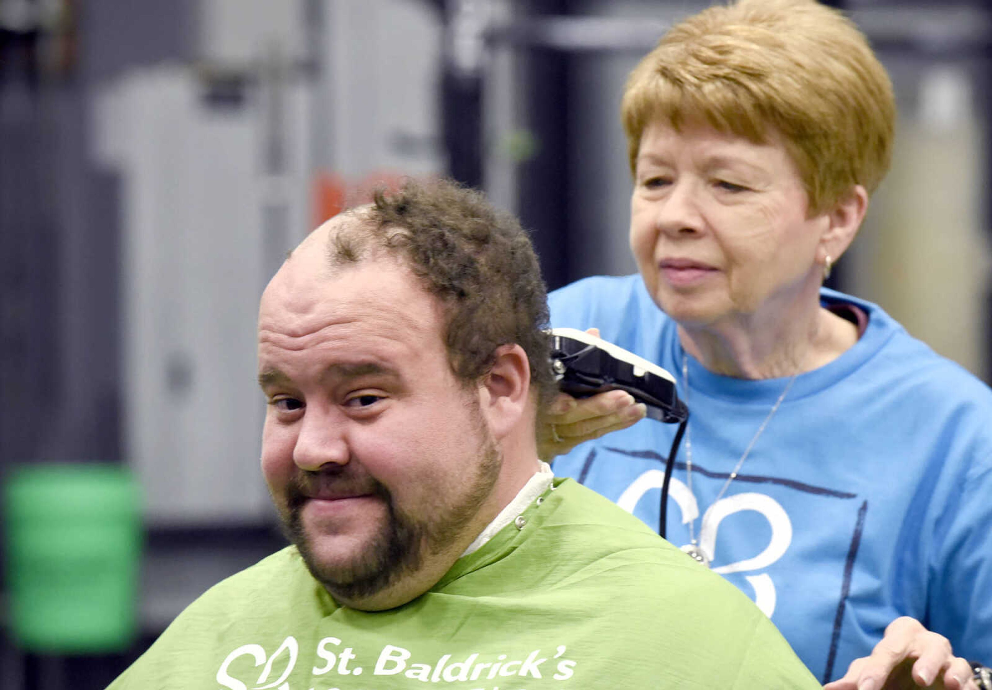 Joe Moss laughs as Jean McLane shaves his head on Saturday, March 4, 2017, during the St. Baldrick's Foundation fundraiser at Old Orchard CrossFit in Jackson.