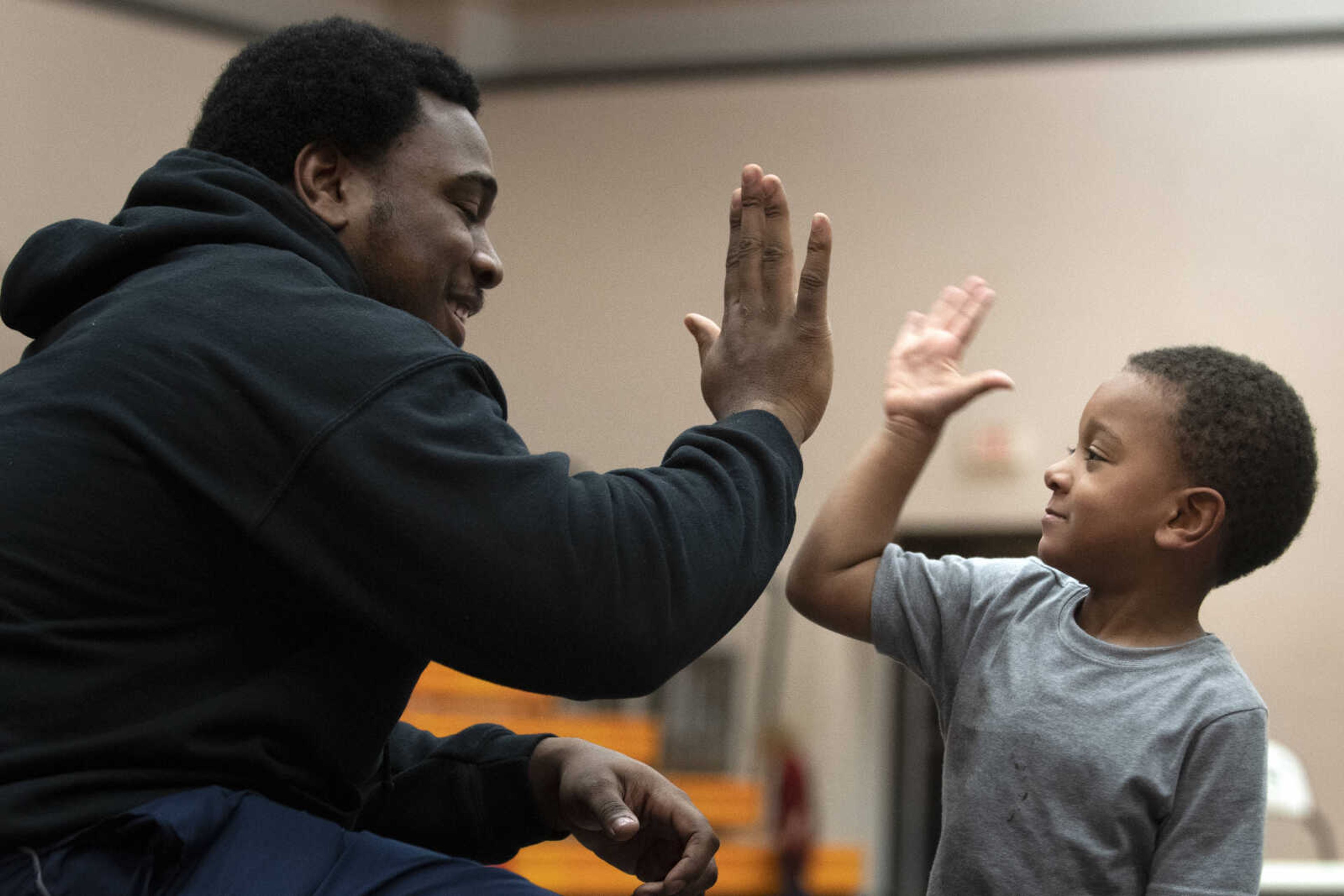 Ronald Coleman Jr., originally of Omaha, Nebraska, and now Cape Girardeau, high fives his son Ronald "Tripp" Coleman III, 3, during a match Tuesday, March 19, 2019, at Cape Central High School.