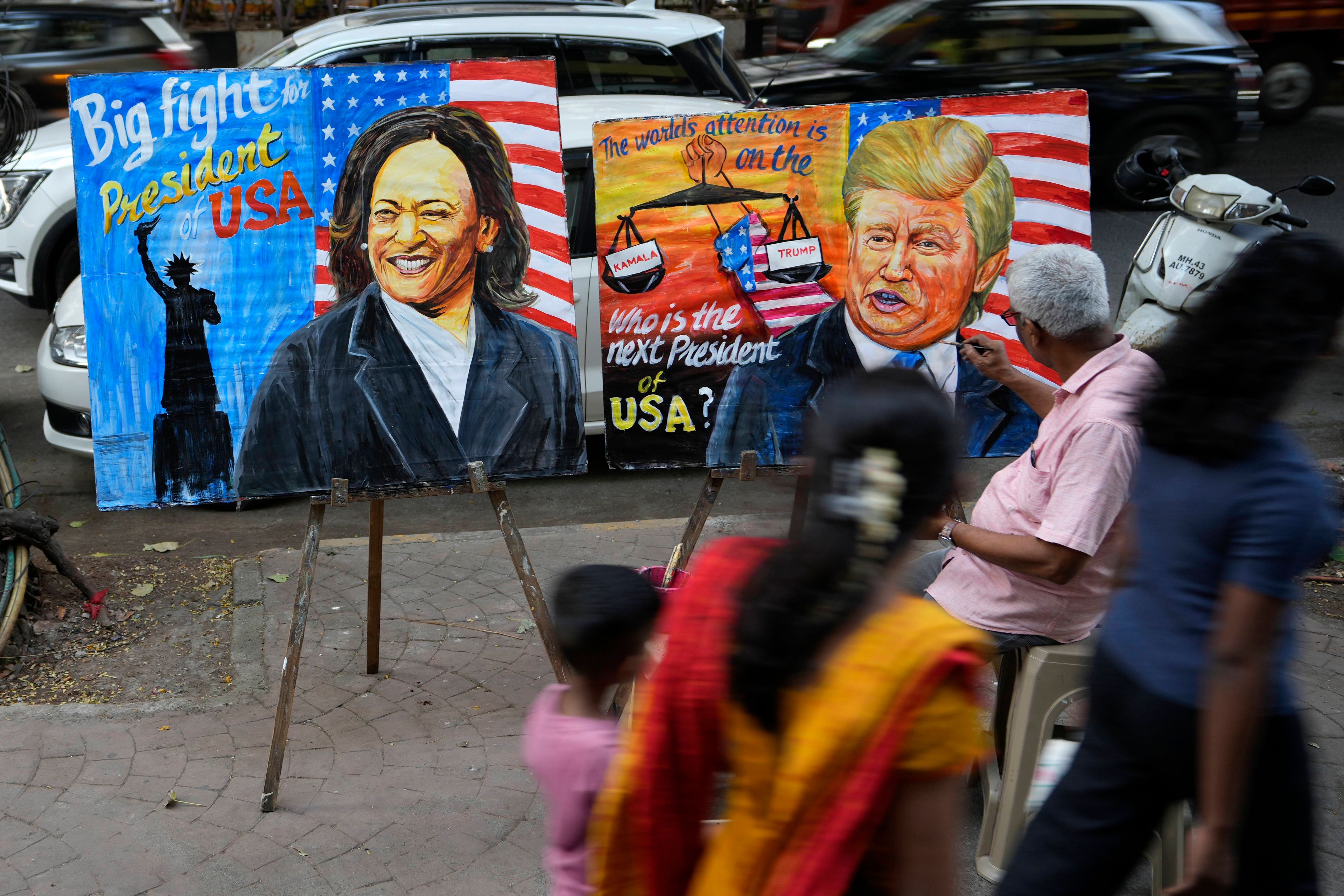 Art teacher Prithviraj Kambli paints posters of US Vice President Kamala Harris and former US President Donald Trump outside his school in Mumbai, India, Tuesday, Nov. 5, 2024. (AP Photo/Rajanish Kakade)