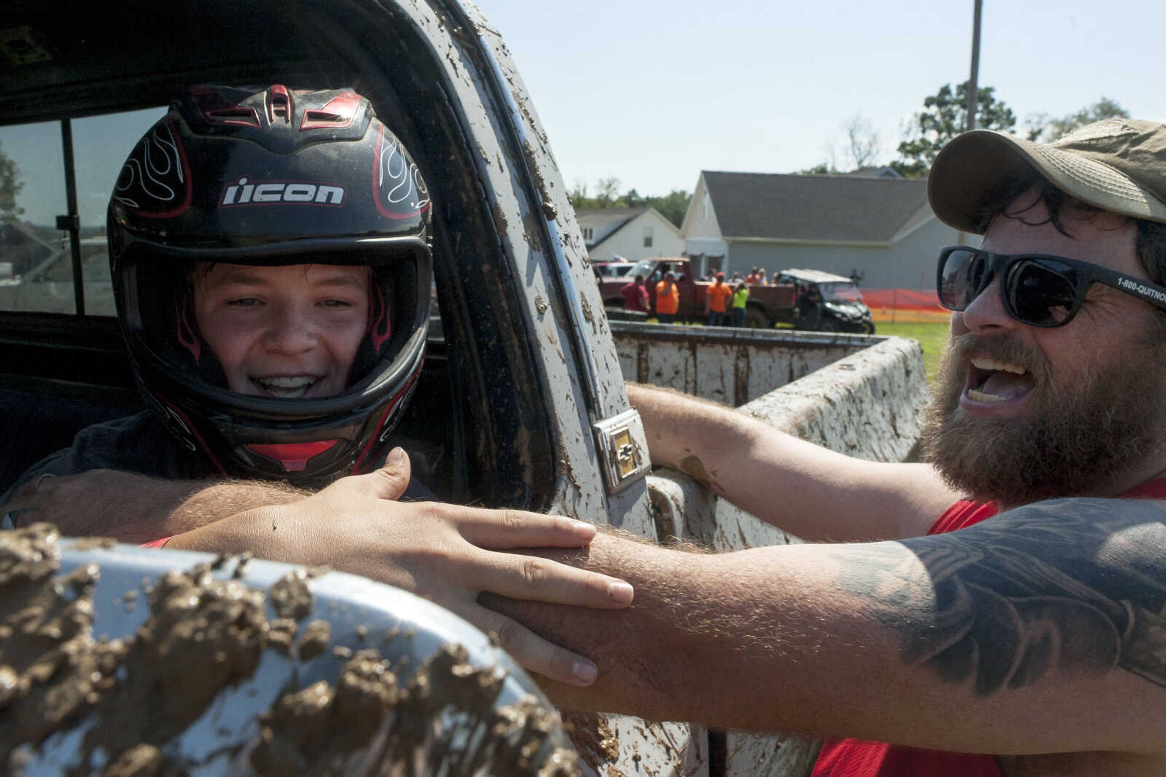 Matthew Jenkins, left, is congratulated by his father, Rick, after crossing the finish line at the annual mud races during Benton Neighbor Days  Saturday, Aug. 31, 2019 in Benton.