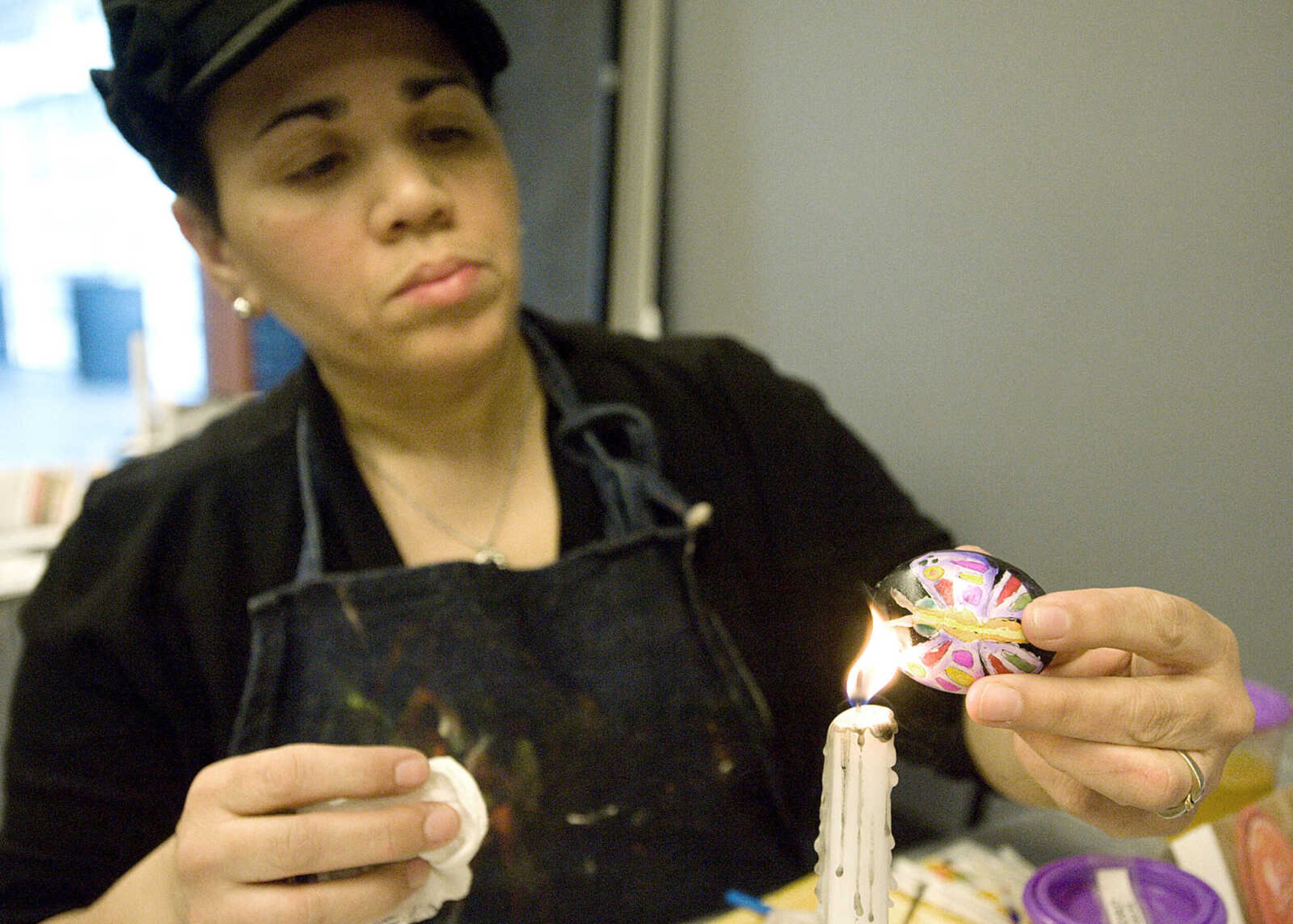 LAURA SIMON ~ lsimon@semissourian.com
Ome Hayward melts the beeswax off of her dyed egg Tuesday, March 19, 2013 during the Wonderful World of Pysanky workshop at Southeast Missouri State University's River Campus. In Pysanky, Ukrainian egg art, each color and design is symbolic. The butterfly on Hayward's egg is a symbol of beauty and the pink represents success and yellow represents recognition and reward. Instructor Barb Duncan has teaching people of all ages the art of Pysanky for 16 years.