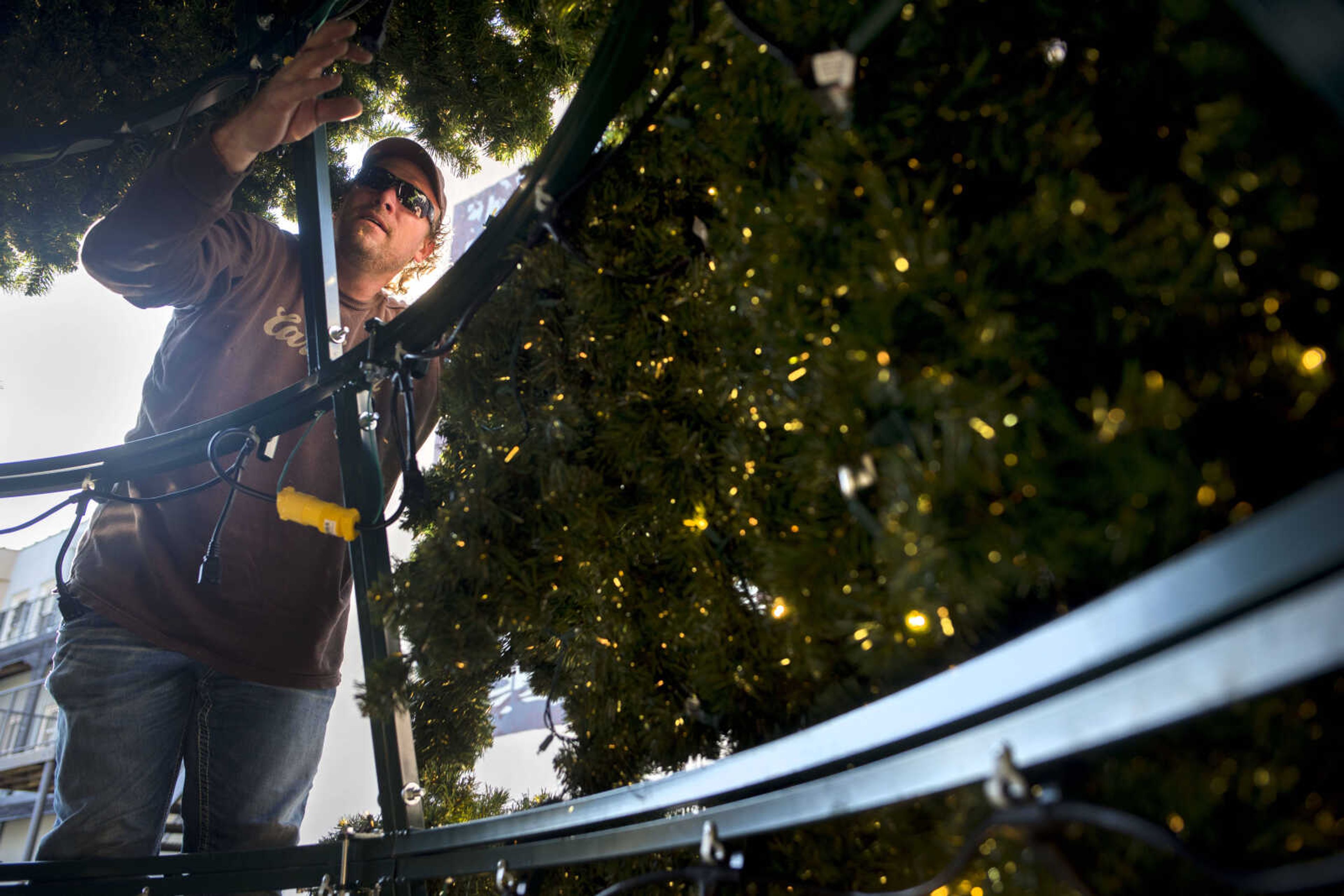 C.B. Forck of Forck's Lite Designs & Guttering adds a branch to a 30-foot Christmas tree Monday, Nov. 25, 2019, in the courtyard of Vasterling Suites in Cape Girardeau.  Old Town Cape will host a tree lighting ceremony Friday at 5:30 p.m., followed by complimentary beverages and snacks and holiday pictures.