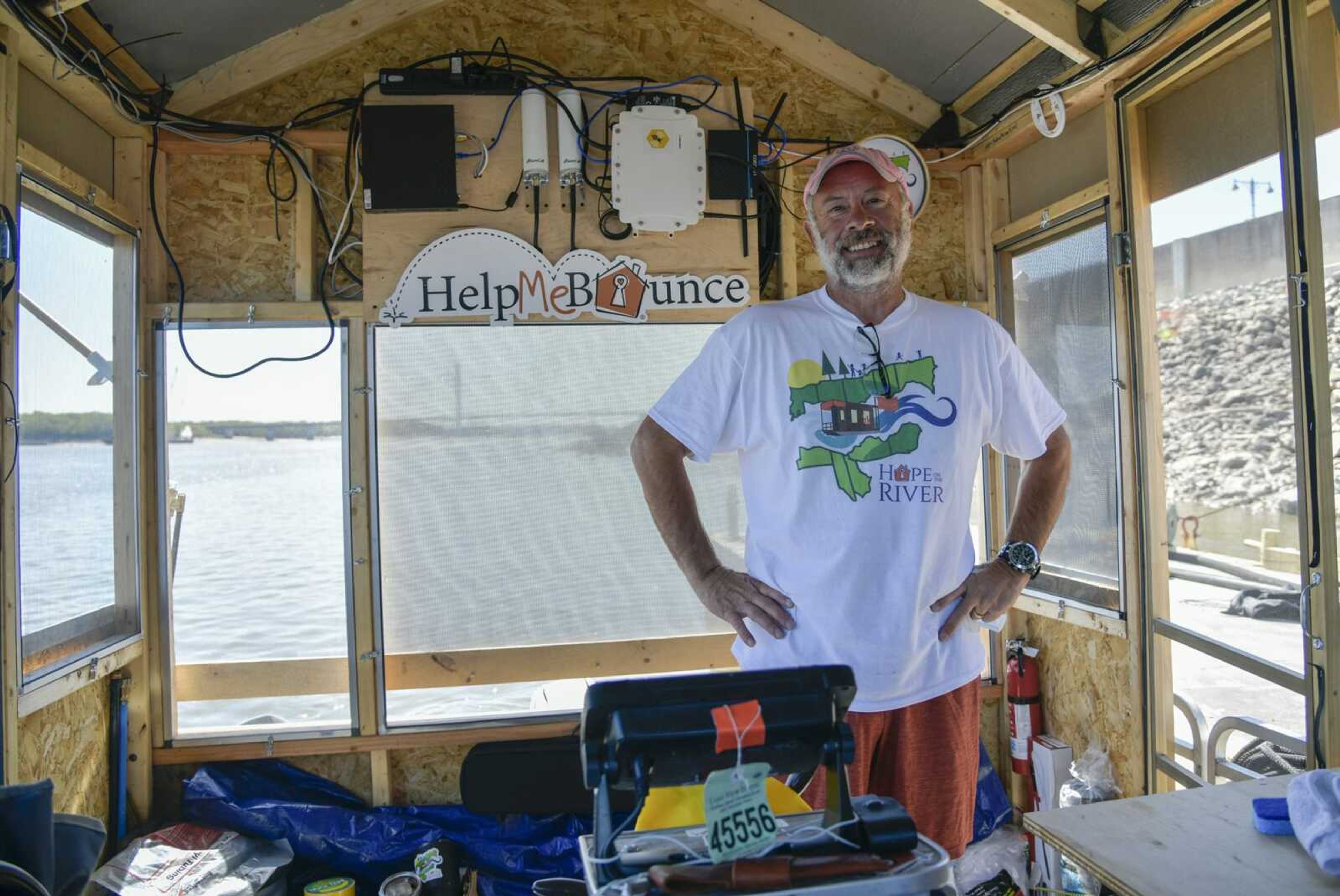 Erich Mische, executive director of Spare Key, stands inside his "homemade raft," named S.S. Hail Mary, on Monday in Cape Girardeau. Mische is using the boat to make a 1,700-mile journey down the Mississippi River from Minnesota to Louisiana to raise funds to help save his organization and and its mission. On the wall above is some of the equipment used to livestream his journey.