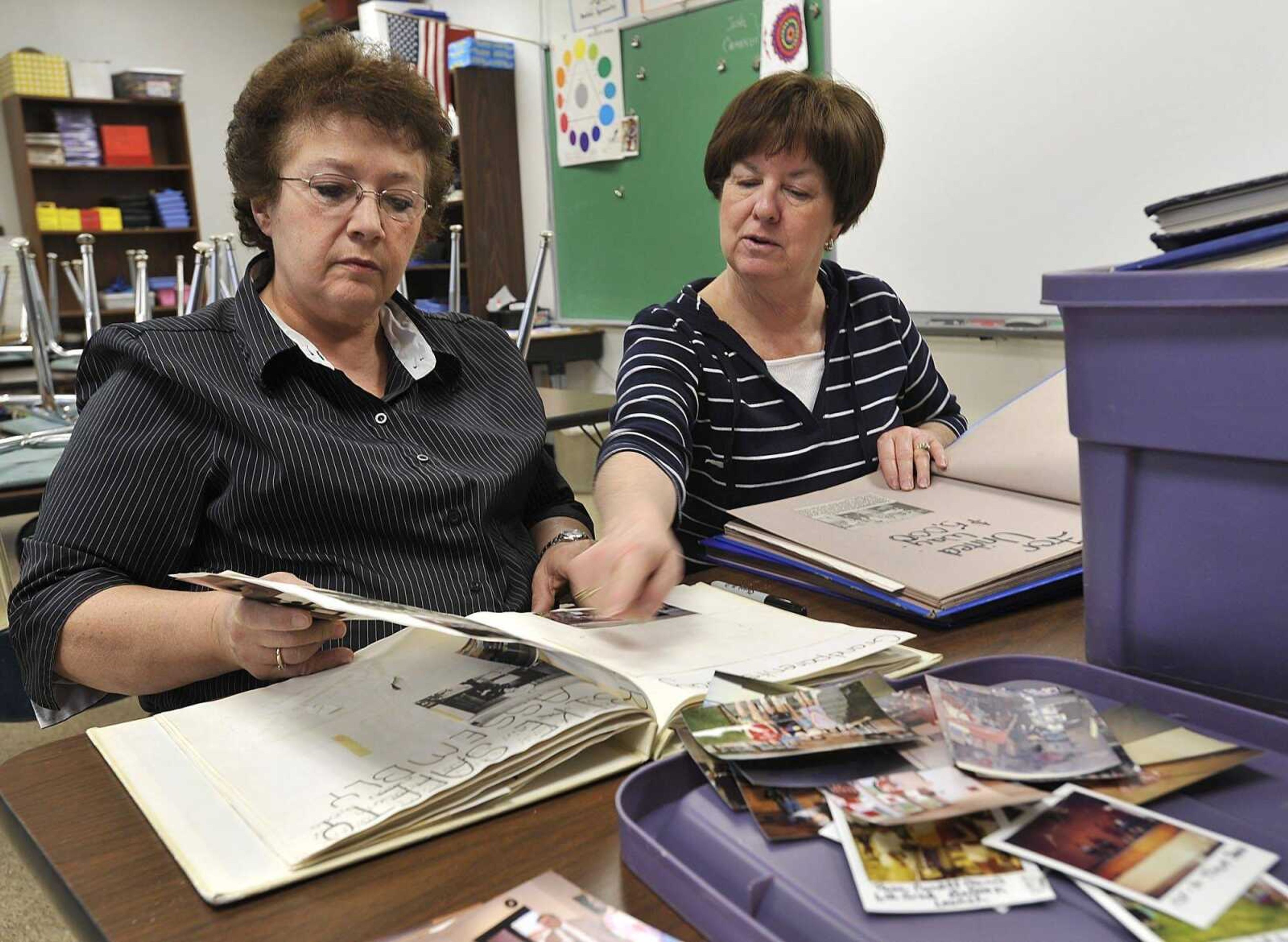 Former Alma Schrader school teachers Rosie Conrad, left, and Sharon Williams look through photo albums in preparation for the school's 50th anniversary celebration. (Fred Lynch)