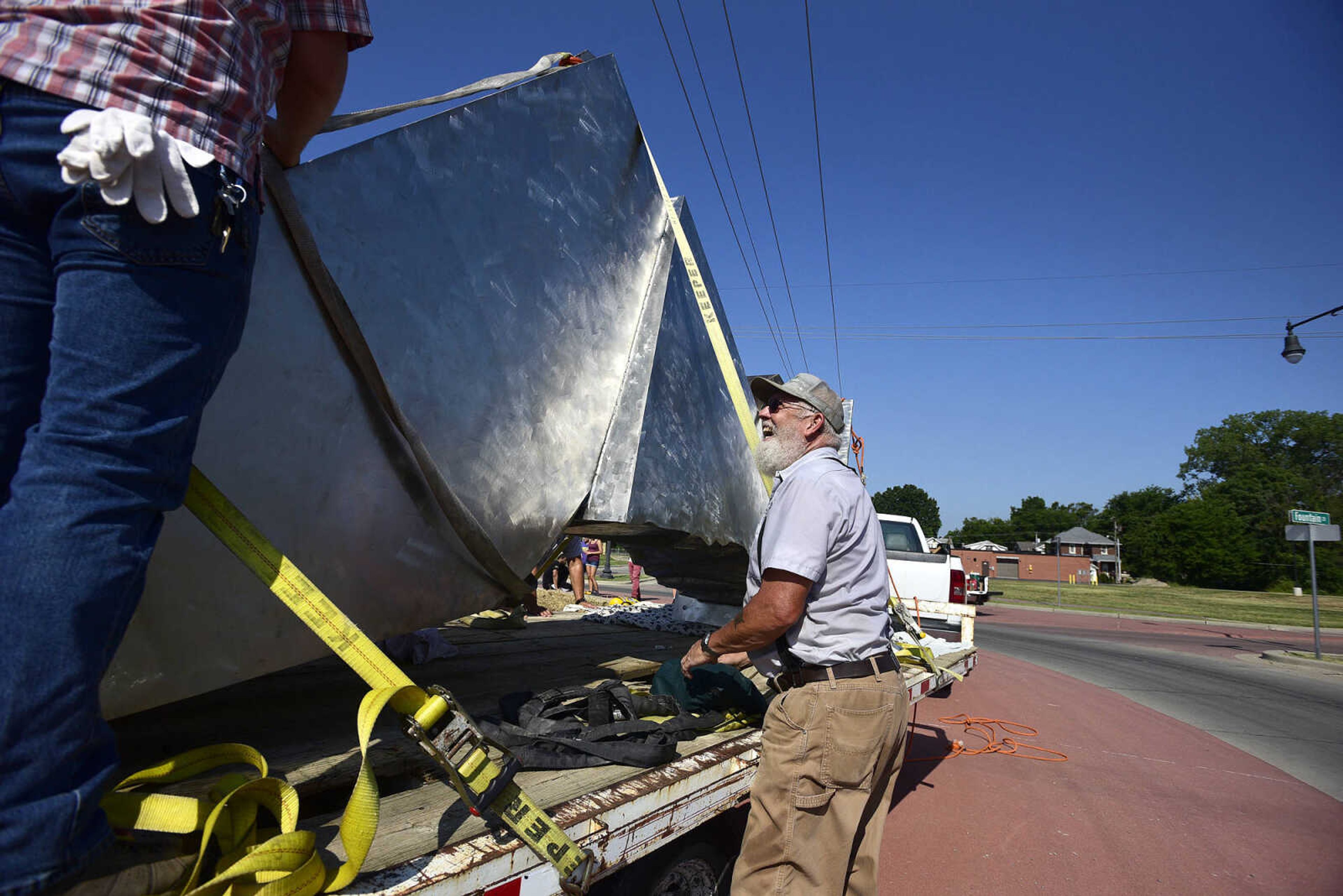 Cape Girardeau Parks and Recreation employees secure a section of Chris Wubbena's 14-foot sculpture, "Commence" to lift for installation in the Fountain Street roundabout on Monday, July 24, 2017, near the River Campus in Cape Girardeau.