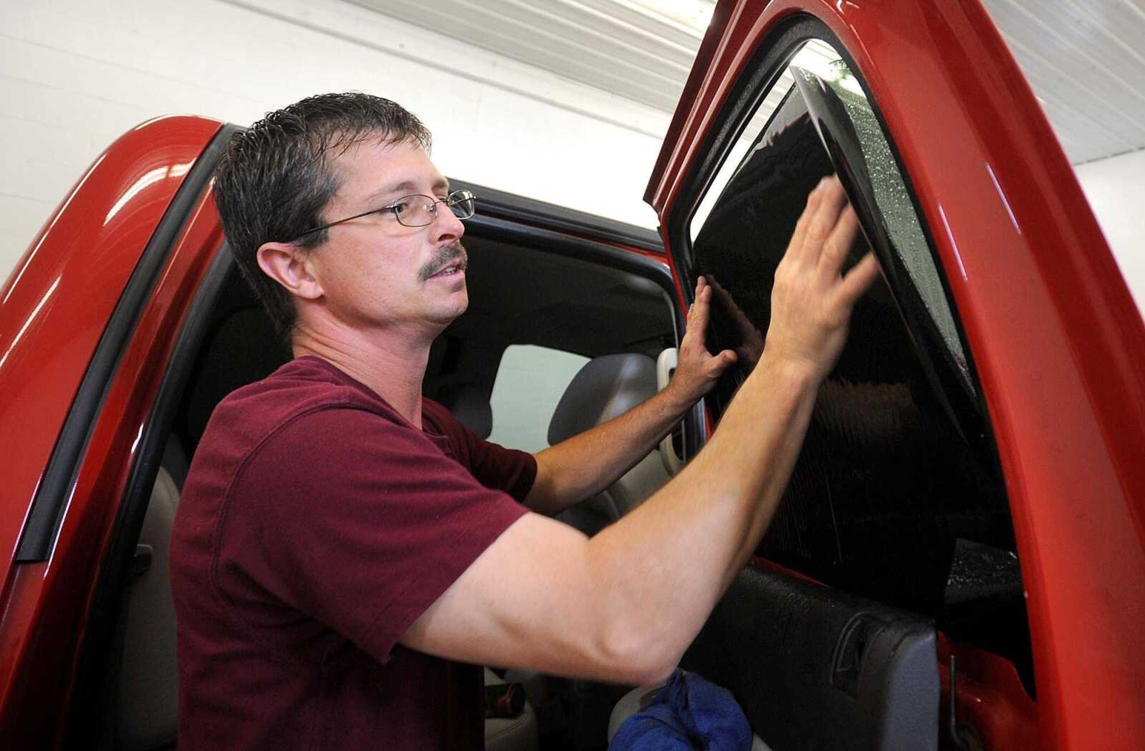 An Edgewater Glass Co. employee adds tinting to the windows of a pickup truck in 2014. The longtime Cape Girardeau business has ceased operations.