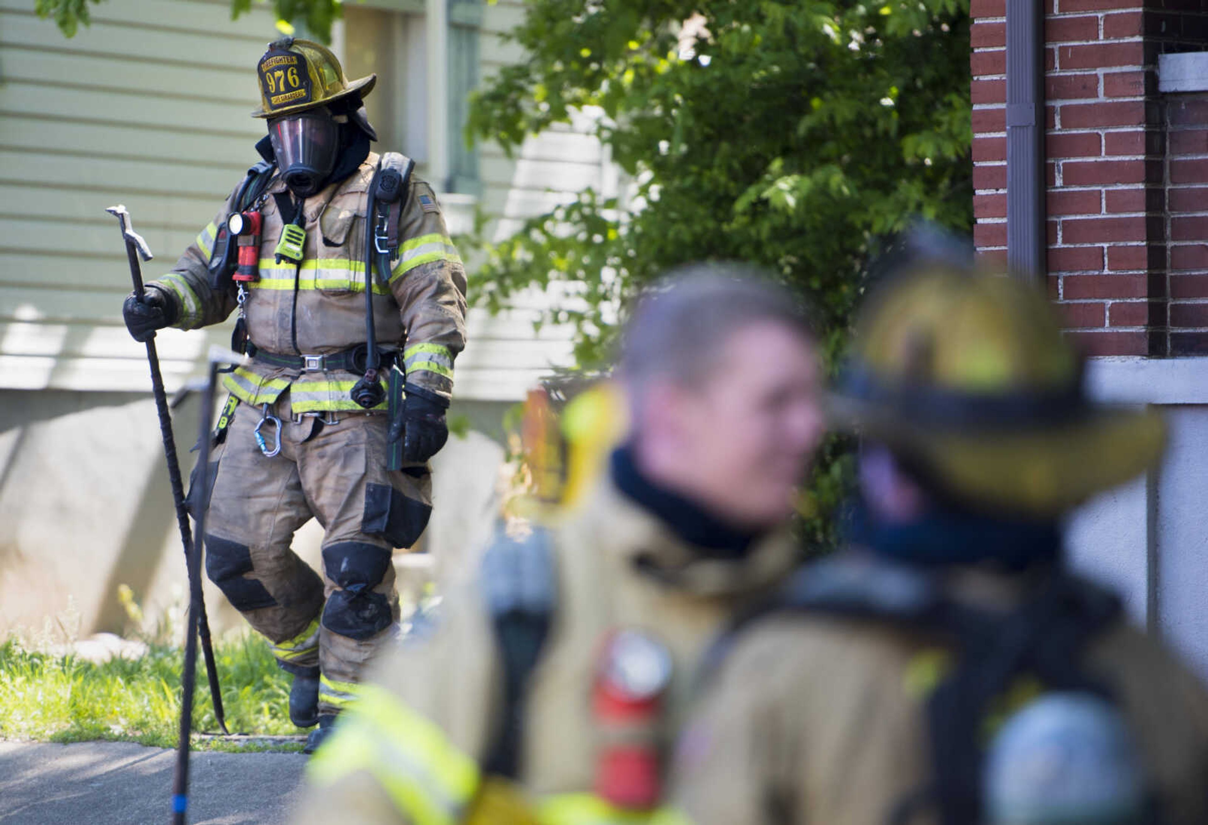 Cape Girardeau firefighter Jamie Hann carries a pike pole away from the scene of a structure fire Monday, May 11, 2020, at 40 North Henderson Ave. in Cape Girardeau. The residence was occupied at the time of the fire, according to Cape Girardeau deputy fire chief Randy Morris Jr., but all residents evacuated safely and no injuries were reported.