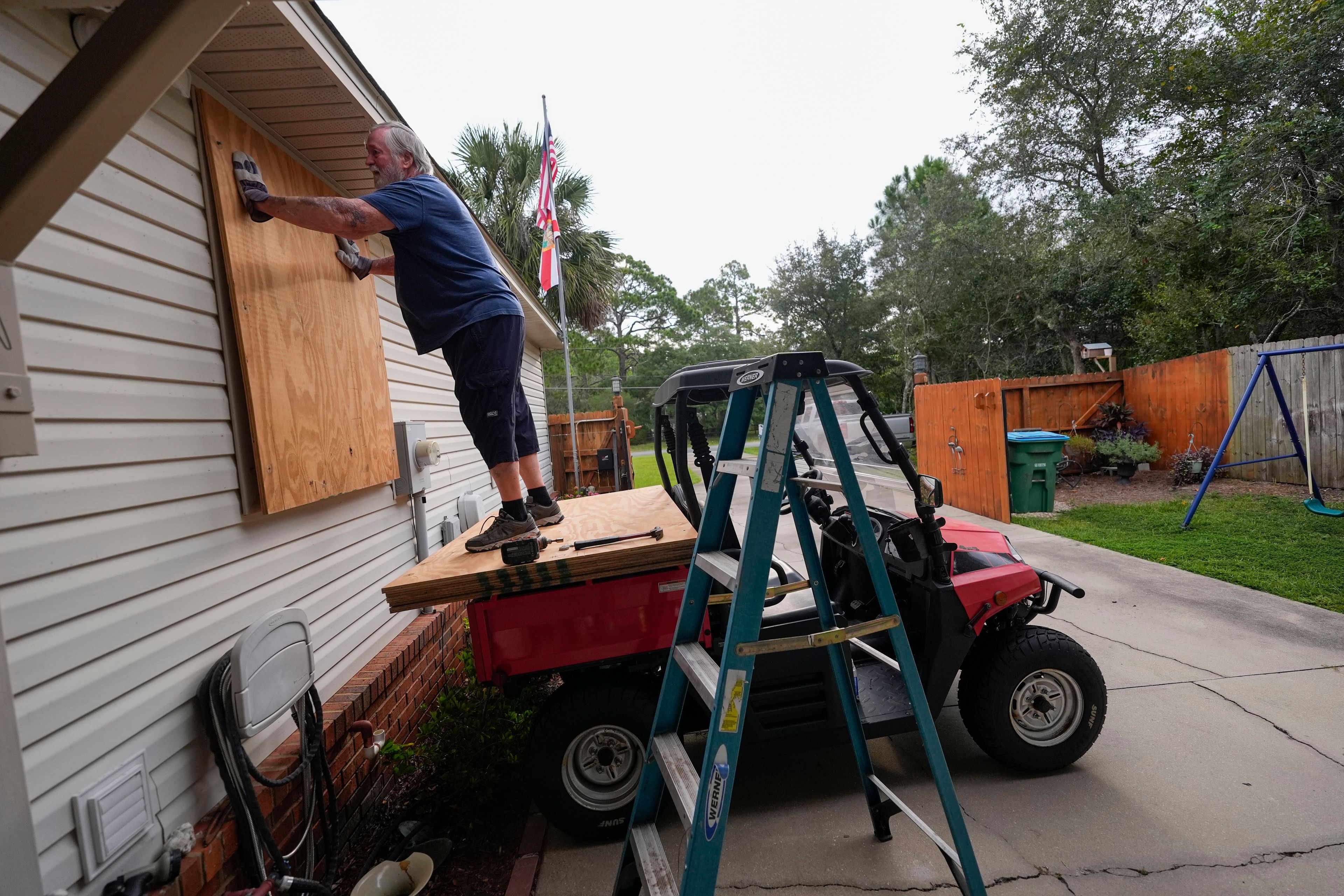 Dave McCurley boards up the windows to his home in advance of Tropical Storm Helene, expected to make landfall as a hurricane, in Ochlockonee Bay, Fla., Wednesday, Sept. 25, 2024. (AP Photo/Gerald Herbert)