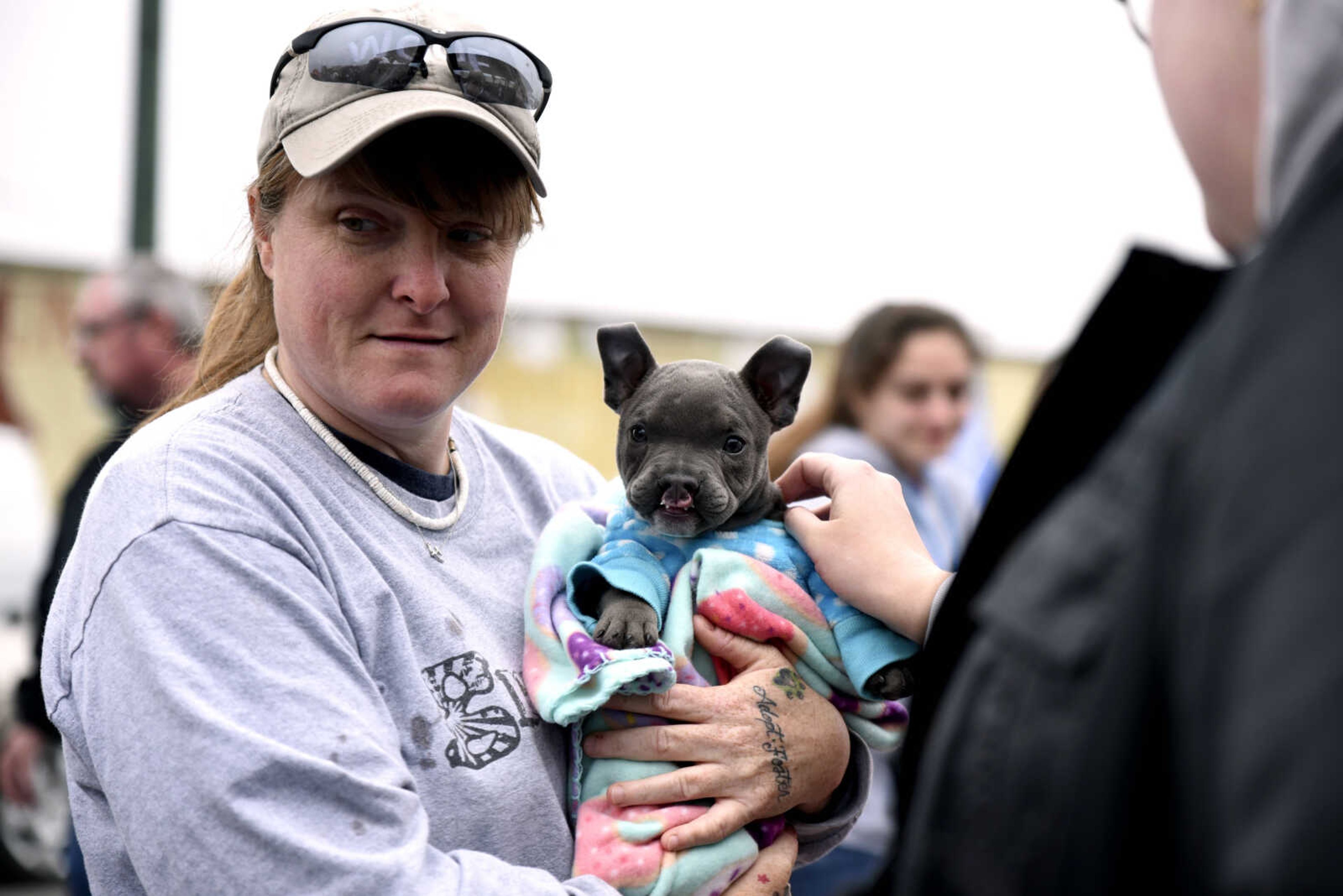 Rochelle Steffen, director of Mac's Mission, holds 10-week-old American bully Quigley before the start of the 2nd Annual Mardi Paws Parade of Pets hosted by Mississippi Mutts on Sunday, March 18, 2018, in downtown Cape Girardeau.