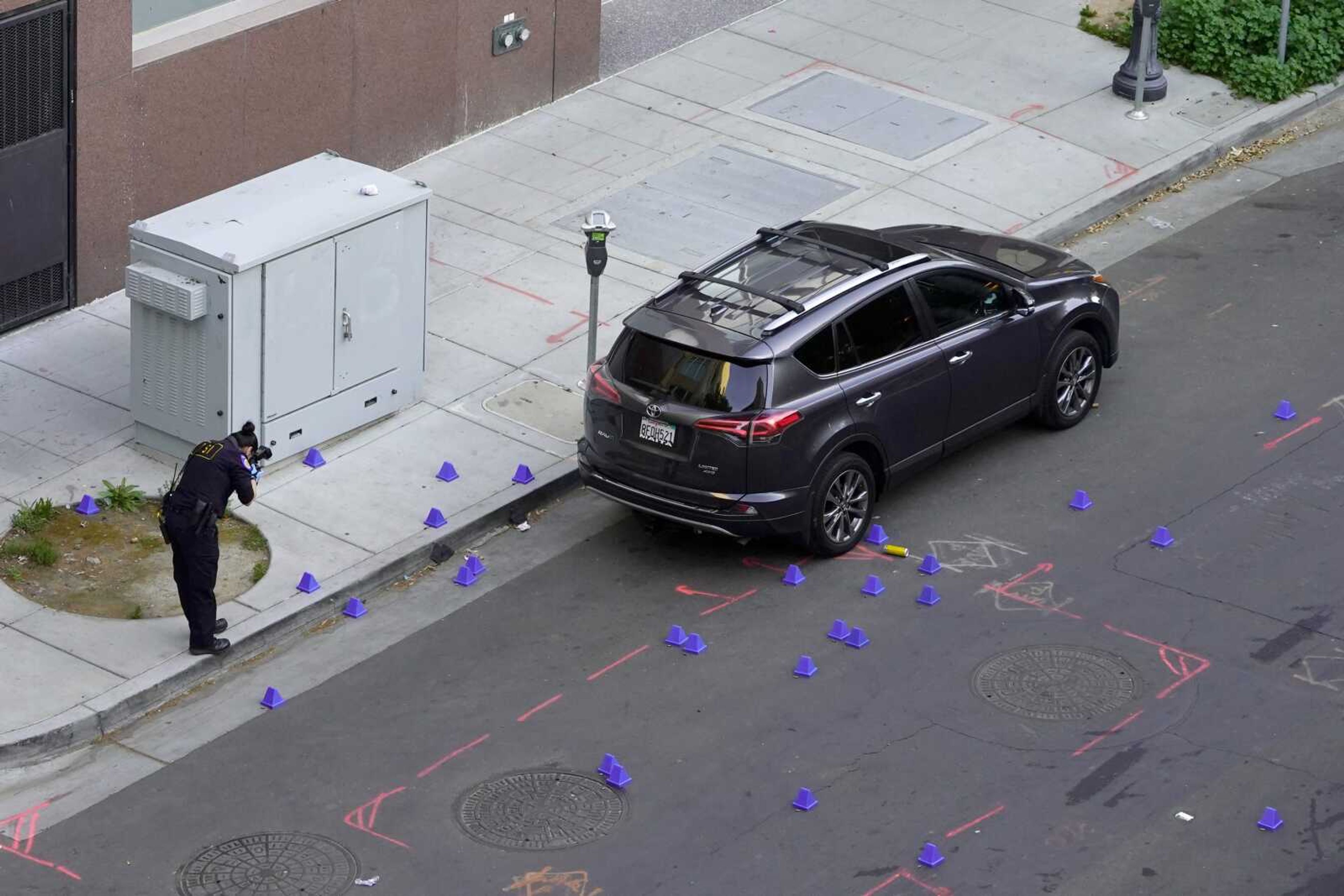 A crime scene investigator photographs evidence markers at the scene of a mass shooting Sunday in Sacramento, California.