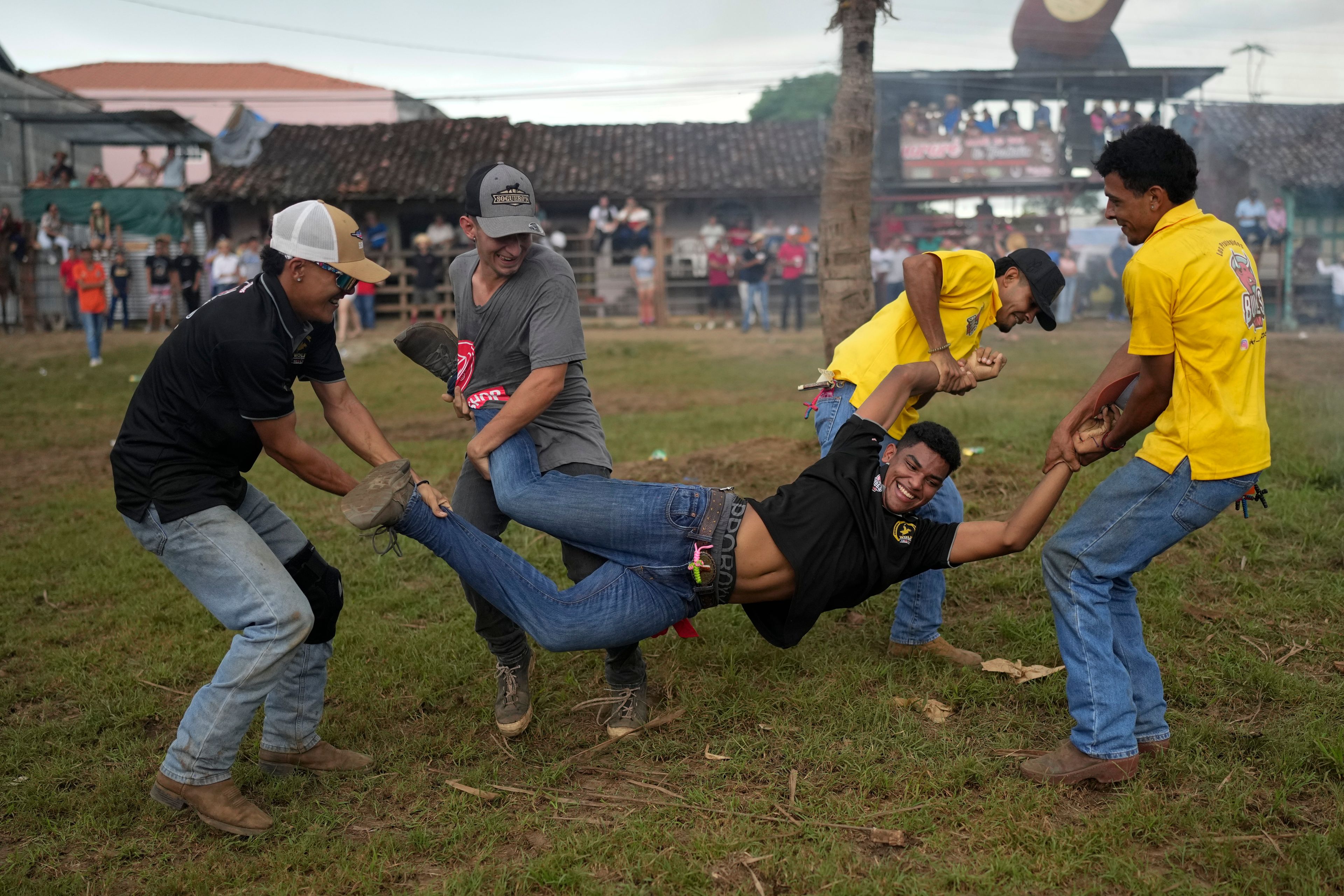 A man is carried by his friends to throw him into the mud during the annual folk festival that celebrates the feast day of Our Lady of Mercedes in Guarare, Panama, Friday, Sept. 27, 2024. (AP Photo/Matias Delacroix)