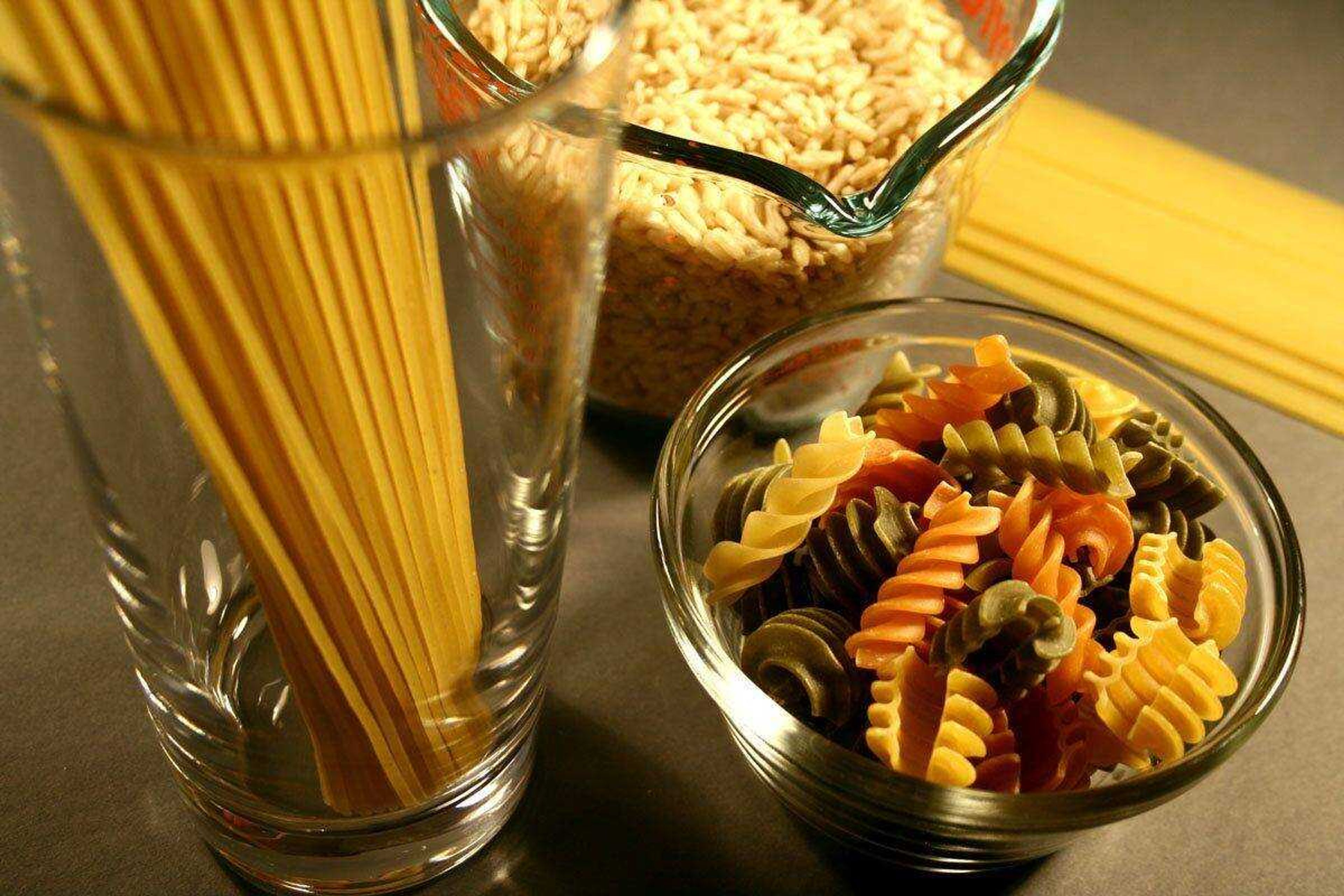 This photograph depicts glass containers filled with uncooked, carbohydrate-rich foods &#8212; spaghetti, rice and multicolored rotini pasta. (Debora Cartagena ~ CDC)