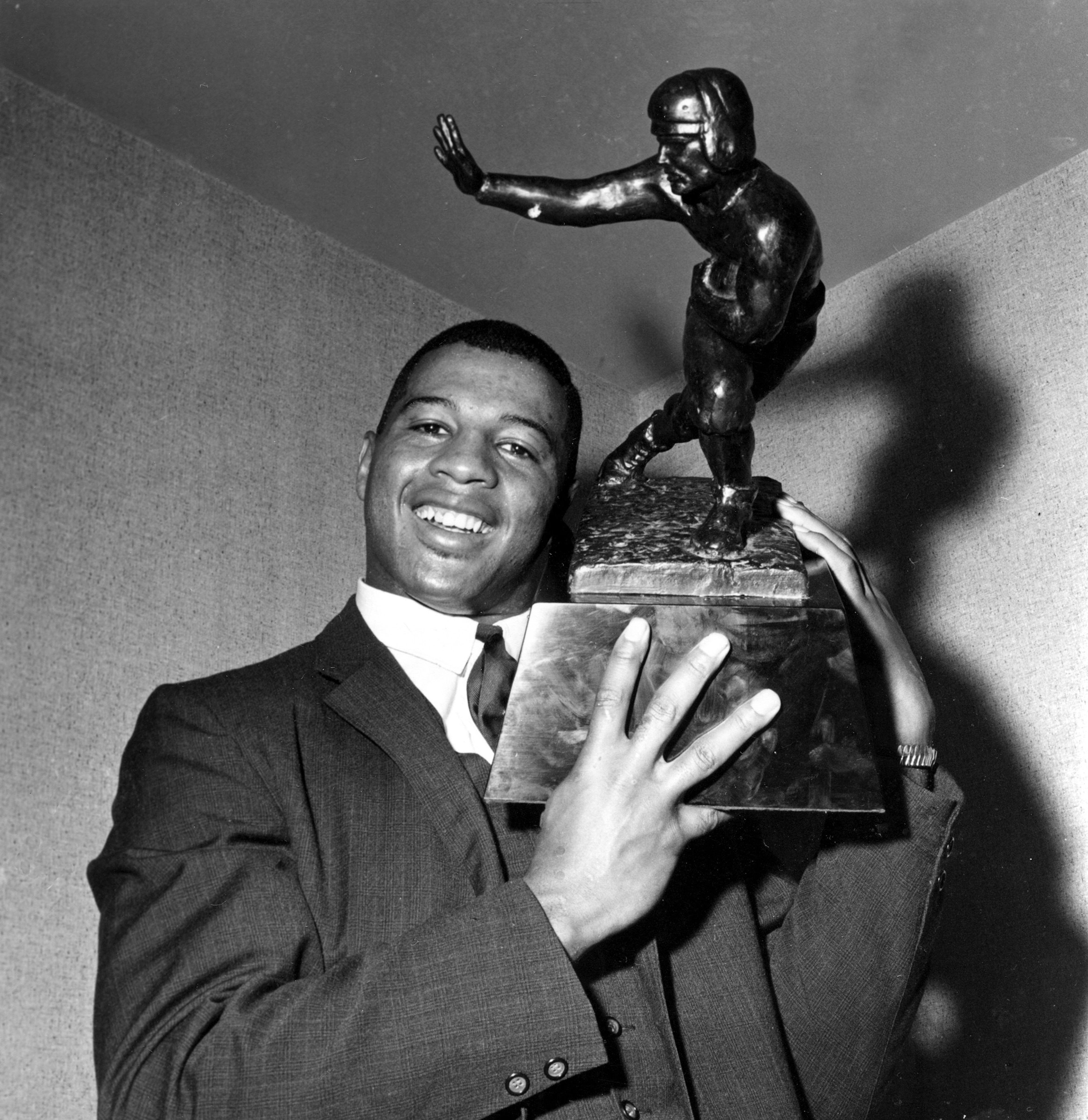 Ernie Davis, halfback for Syracuse, holds the Heisman Trophy prior to official presentation to him in New York City, in this Dec. 6, 1961, file photo. He was the first Black college football player to win the Heisman.