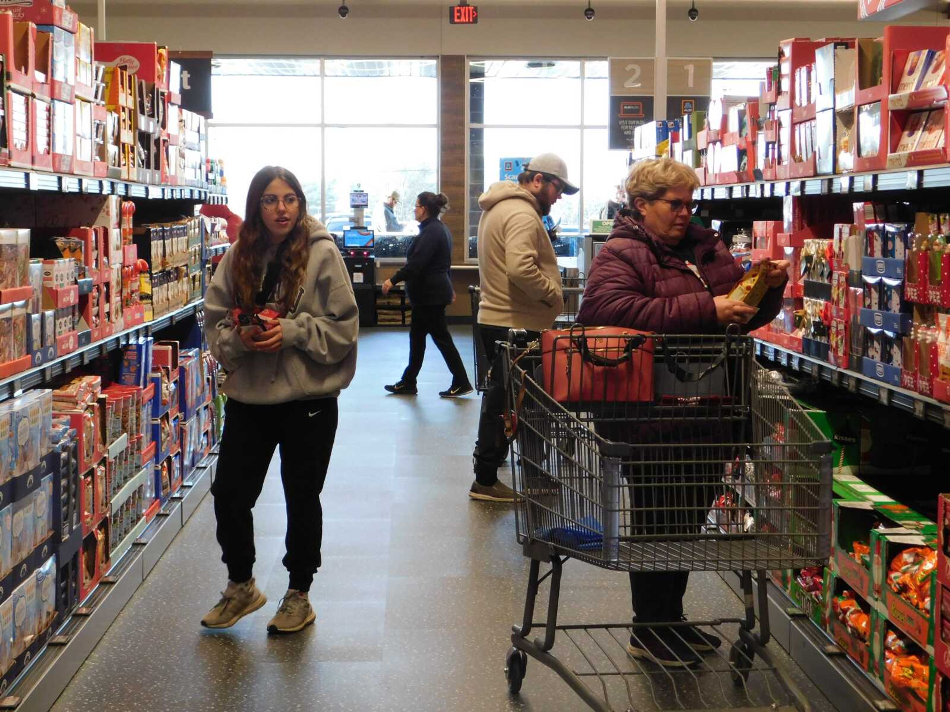 Shoppers Anna Vollink, left, Wyatt Blattel, back, and Darlene Barnhart, right, peruse the aisles Thursday, Dec. 7, after ALDI opened its first store in Jackson. Barnhart said she liked shopping at ALDI because it offers different products than other stores do.