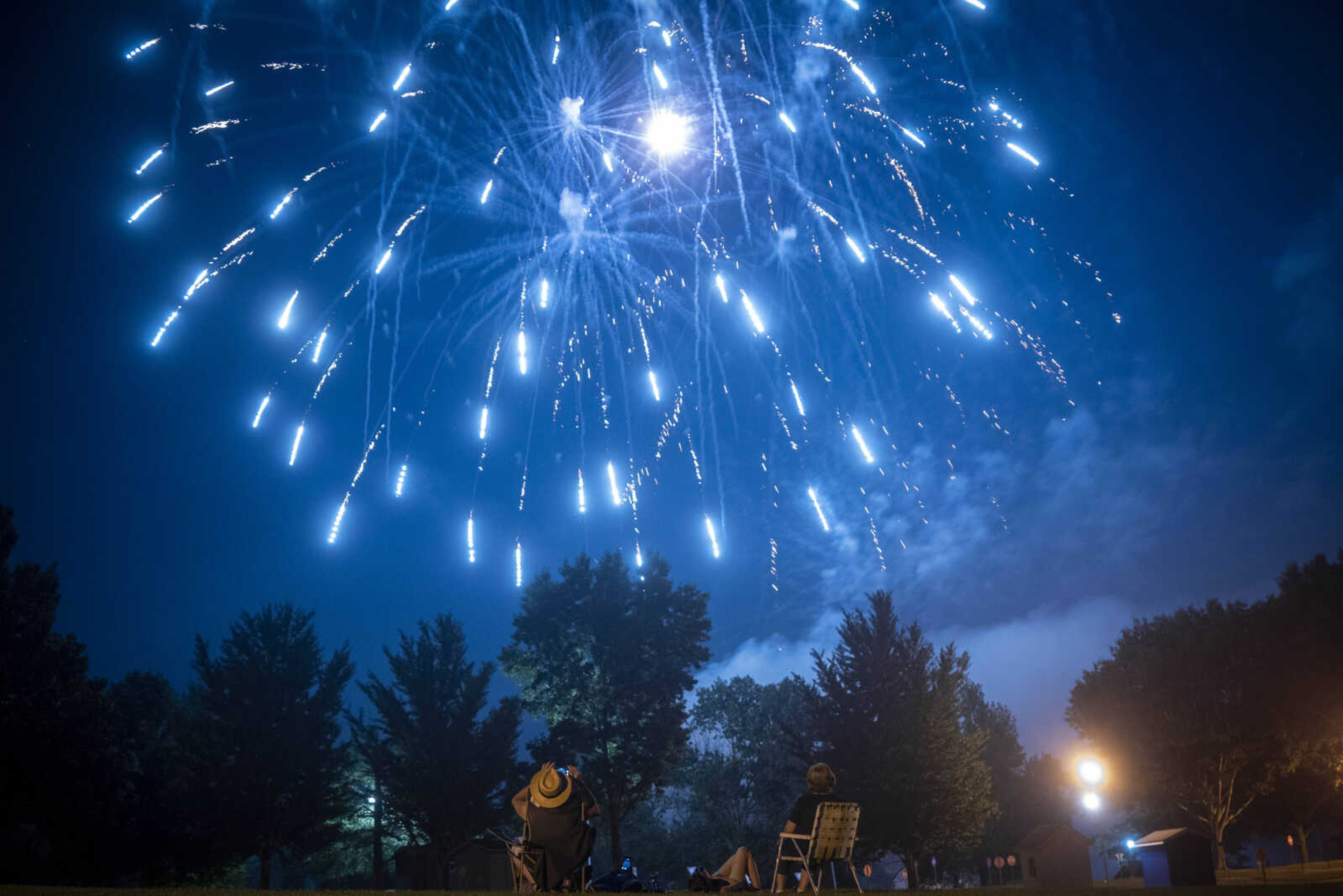 Spectators view a fireworks display during an Independence Day celebration at the Jackson Municipal Band Shell.