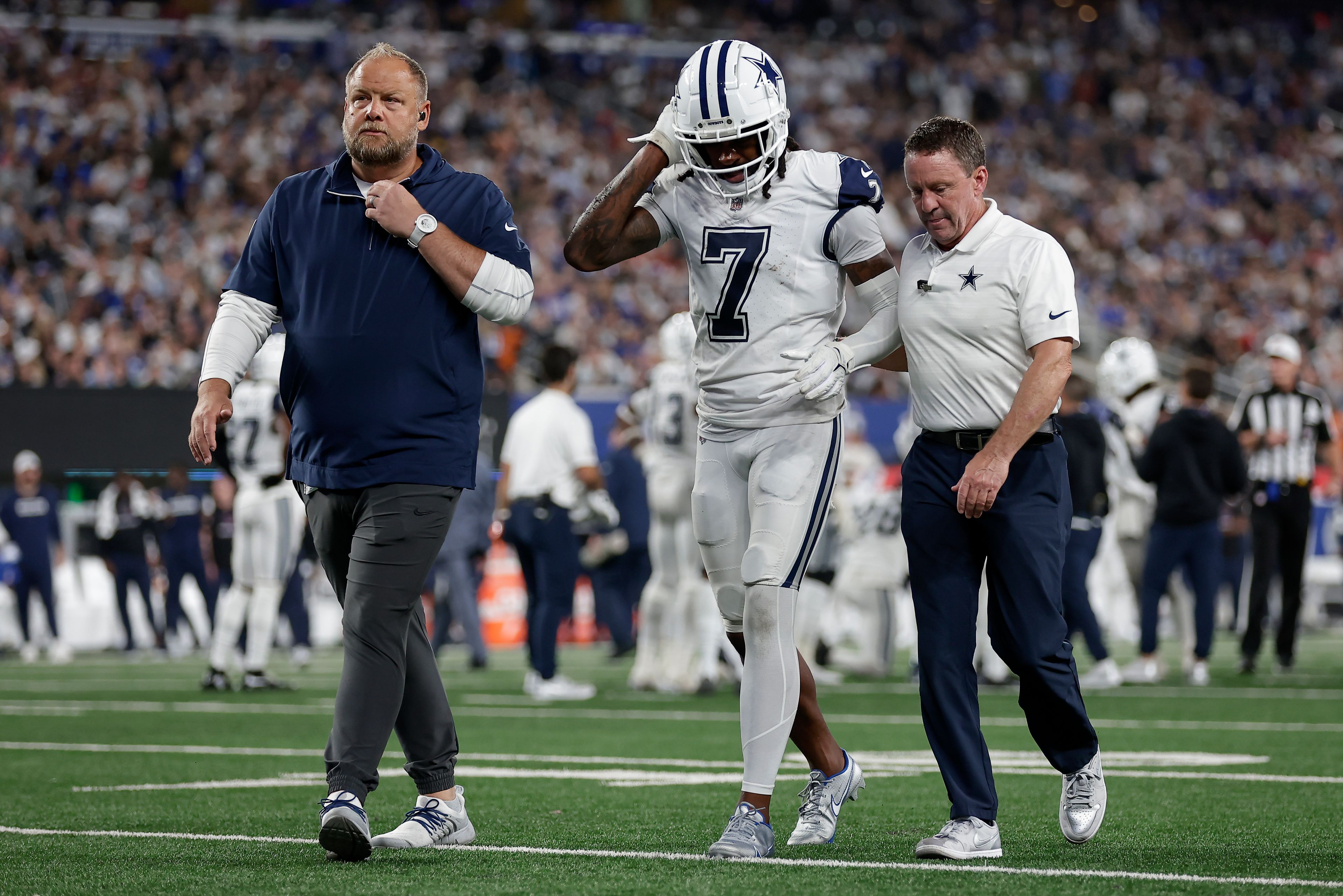 Dallas Cowboys cornerback Trevon Diggs (7) walks off the field with trainers during the third quarter of an NFL football game against the New York Giants, Thursday, Sept. 26, 2024, in East Rutherford, N.J. (AP Photo/Adam Hunger)