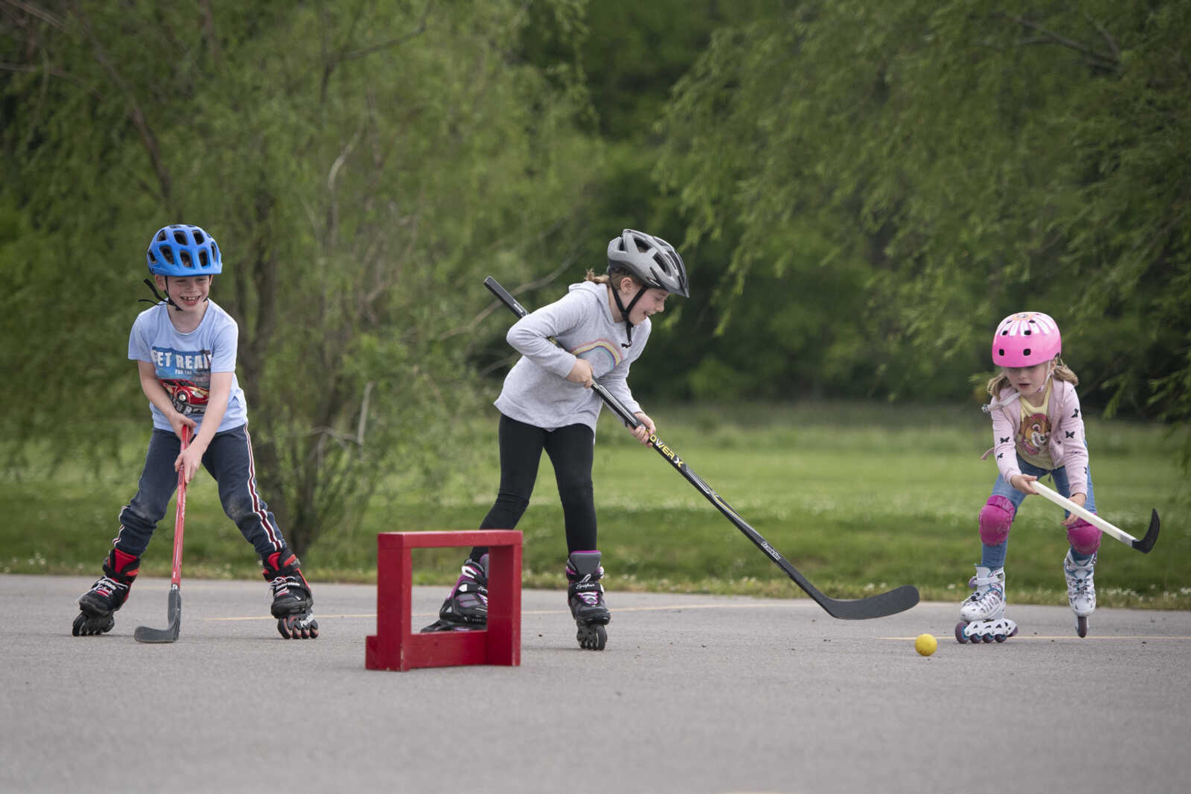 Booch siblings of Cape Girardeau, from left, Henri, 7, Emma, 9, and Matilda, 5, play hockey with their mother, Maren Booch (not pictured), on Wednesday, May 20, 2020, at a parking lot near Cape Splash Family Aquatic Center in Cape Girardeau. Maren said hockey in the parking lot has become a regular activity for the family during the COVID-19 pandemic. "We were looking for a spot and as long nobody parks his car here, that's a perfect spot so we do it almost every afternoon. Sometimes twice a day. When my husband's home, he has to come with us too after dinner," Maren said. "As long as it's not raining, we're here."