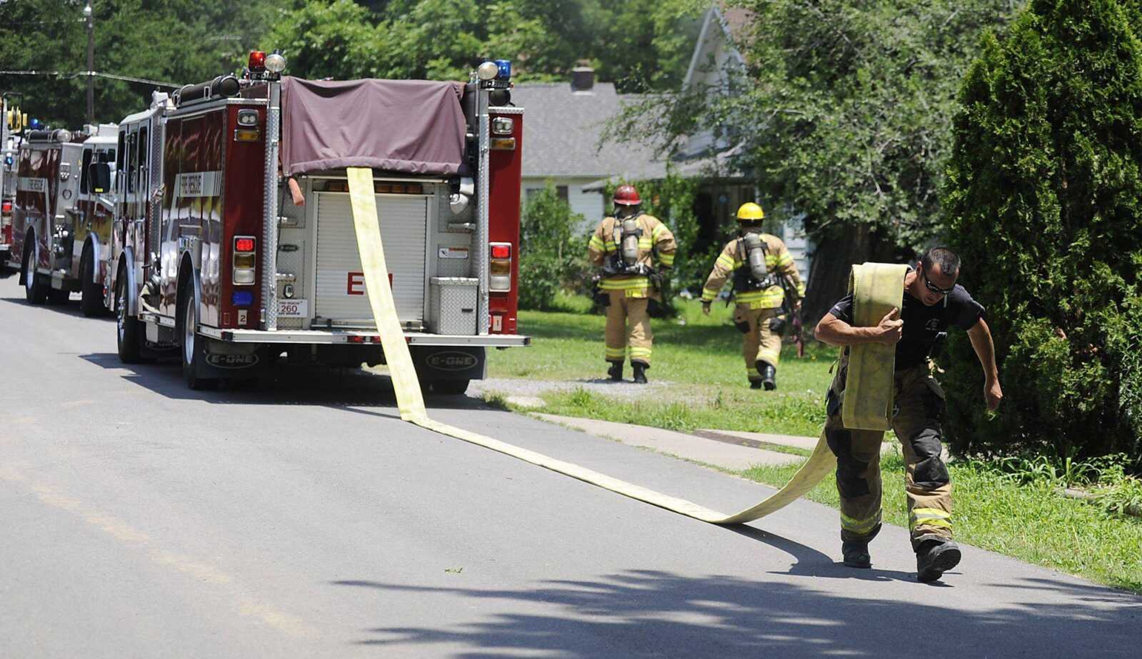 A member of the Cape Girardeau Fire Department runs a hose to a fire hydrant Friday when responding to a house fire at 1222 N. Spanish St. in Cape Girardeau. No one was injured in the fire. An unidentified woman was transported by ambulance to a hospital for medical treatment not associated with the fire. A fire department report said the blaze was caused by a faulty window air conditioner. firefighters had the flames under control in about 10 minutes. (Adam Vogler)