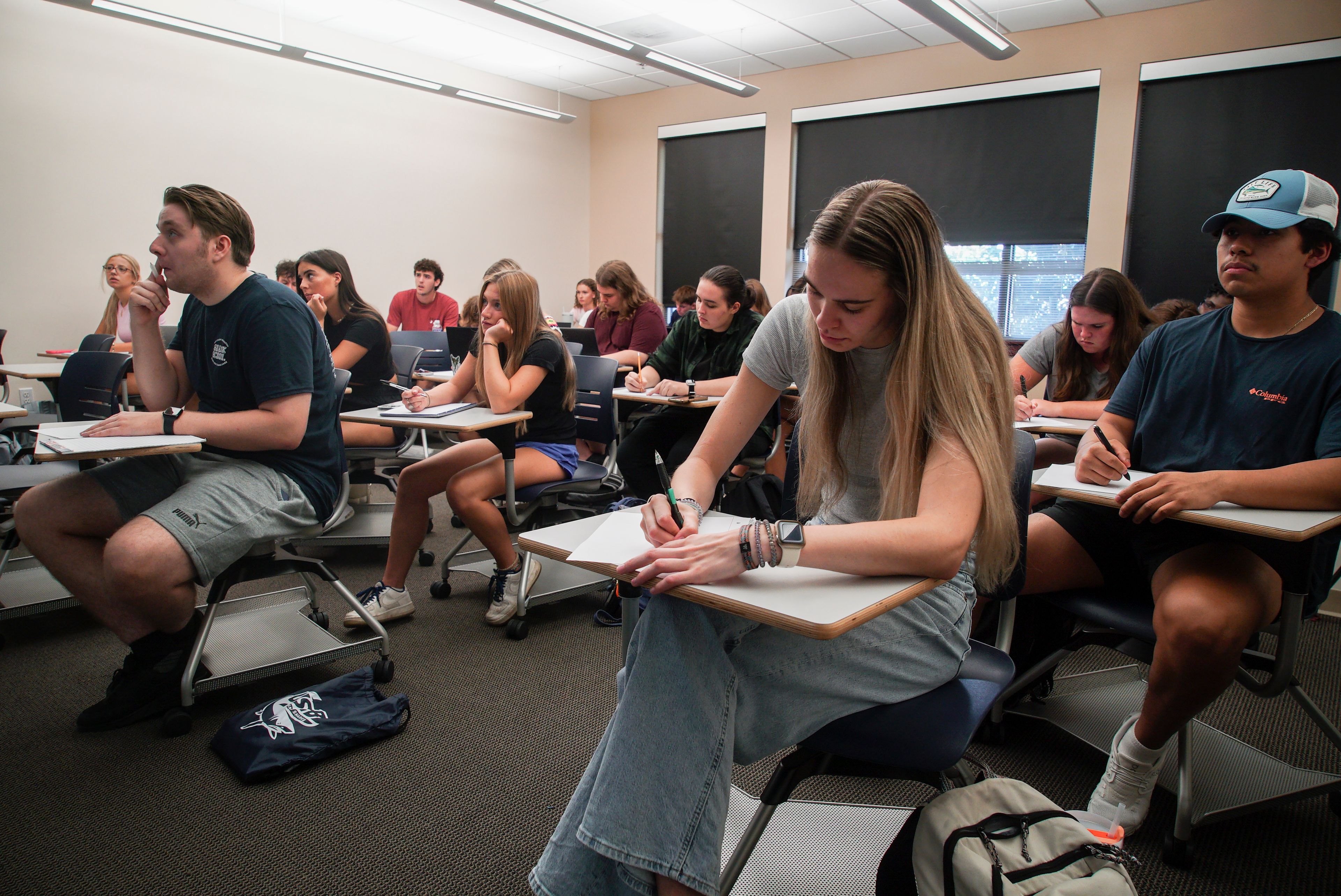 Audra Hillman, 18, foreground right, a freshman at the University of South Carolina Beaufort, takes a modified citizenship quiz during an American government class in Bluffton, S.C., on Tuesday, Aug. 20, 2024. (AP Photo/Allen G. Breed)